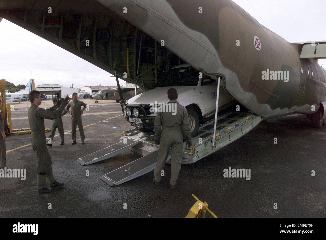 Right side rear medium shot as a Portugese Aircrew and local laborers load a vechicle onto a Portugese C-130 at the International Airport at Maputo, Mozambique, Africa on 17 March 2000. The aircraft and its crew are deployed to Maputo in support of Operation Atlas Response, a Humanitarian Aid Operation to help the people of Mozambique after severe flooding (flooding and victims not shown) displaced over a million people from their homes. Subject Operation/Series: ATLAS RESPONSE Base: Maputo State: Inhambane Country: Mozambique (MOZ) Stock Photo