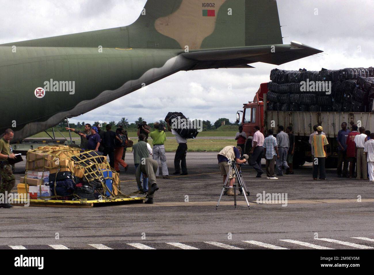 Medium long shot. A Portugese Aircrew and local laborers load humanitiarian relief supplies onto a Portugese C-130 at the International Airport at Maputo, Mozambique, Africa, on 17 March 2000. The aircraft and its crew are deployed to Maputo, in support of Operation Atlas Response, a Humanitarian Aid Operation to help the people of Mozambique, after severe flooding displaced over a million people from their homes. Subject Operation/Series: ATLAS RESPONSE Base: Maputo State: Inhambane Country: Mozambique (MOZ) Stock Photo