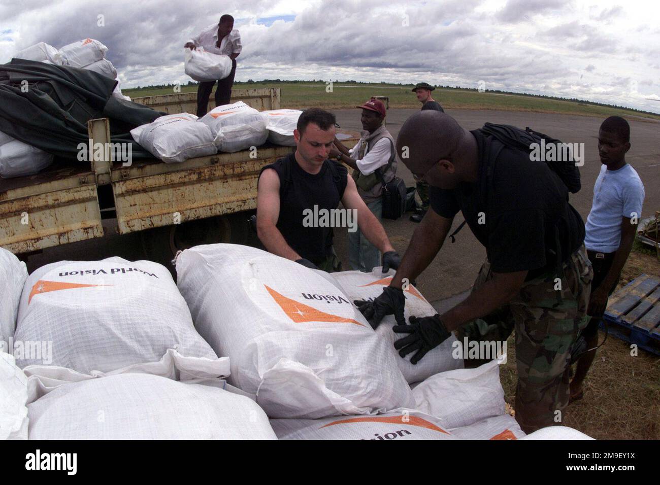 Medium shot. SENIOR AIRMAN Jad Aoun, and Technical Sergeant. Dennis Washington, both Air Transportation Specialists and members of the 86th Air Mobility Squadron, Ramstein Air Base, Germany, with help of local laborers, build pallets of humanitarian supplies at the International Airport at Maputo, Mozambique, Africa, 17 March 2000. Their team is deployed in support of Operation Atlas Response, a Humanitarian Aid Operation to help the people of Mozambique, after severe flooding displaced over a million people from their homes. Subject Operation/Series: ATLAS RESPONSE Base: Maputo State: Inhamba Stock Photo
