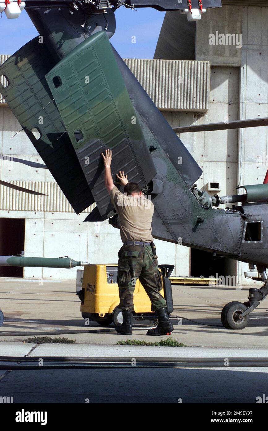 Medium long shot. AIRMAN First Class Brewster Esses, a MH-60 Pave Hawk Crew CHIEF, from the 41st Rescue Squadron, Moody Air Force Base, Georgia, makes ready his helicopter, for transport aboard a C-5 back at Air Force Base Hoedspruit, South Africa, after they arrived from Beira, Mozambique, where they delivered relief supplies to the far reaches of the country, as Operation Atlas Response, a humantiarian relief mission in southern Africa comes to a close. Subject Operation/Series: ATLAS RESPONSE Base: Hoedspruit Air Force Base Country: South Africa (ZAF) Stock Photo