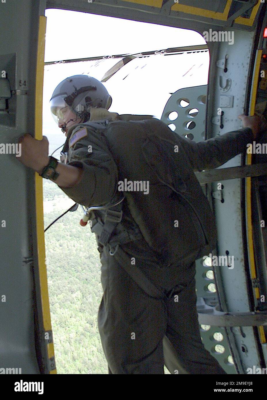 SENIOR AIRMAN Pete Hetherington, USAF, Loadmaster, 6th Airlift Squadron, McGuire Air Force Base, New Jersey, standing in the open door of a C-141B Starlifter checking drop zone conditions before paratroopers of the 82nd Airborne Division, Fort Bragg, North Carolina make their jump. The mission called for the insertion of 1200 Airborne troops from the 82nd onto the drop zone at Fort Polk, Louisiana. The exercise, called Large Package Week involves the airdropping of paratroopers from the 82nd Airborne and their heavy equipment onto the drop zone. Large Package Week is a quarterly training exerc Stock Photo