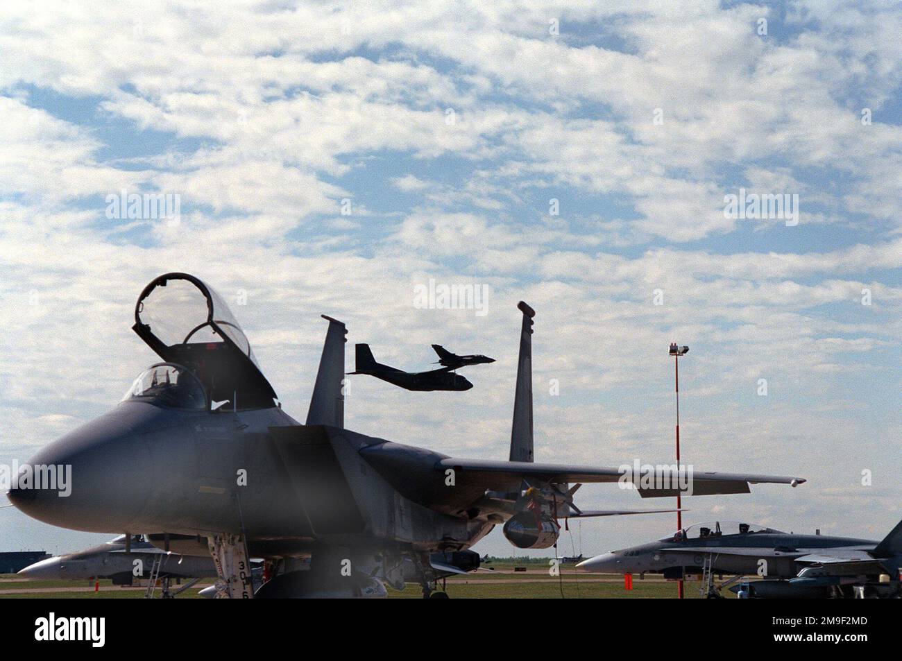 A US Air Force F-15 Eagle (Foreground), from the 173rd Fighter Wing, Kingsley Field, Klamath Falls, Oregon, waits quietly for its next mission, while in the background a Canadian Forces F-16 Falcon taxis behind the F-15. In the air and in the background are a Transall C-160 Cargo plane and a MFG 2 Tornado flown by the German Air Force. The 173rd Fighter Wing was one of the many bases deployed in May 2000 for the Maple Flag Exercise at 4-Wing Cold Lake, Alberta, Canada. Subject Operation/Series: MAPLE FLAG 2000 Base: 4-Wing Cold Lake State: Alberta (AB) Country: Canada (CAN) Stock Photo