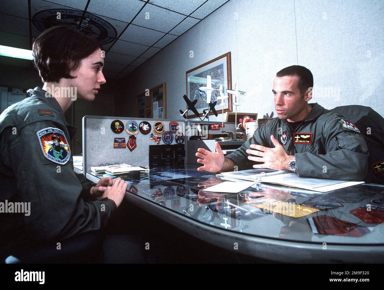 US Air Force Captain Mike Brazelton an instructor pilot at Vance AFB, Oklahoma listens to 2nd Lieutenant Molly Morris spell out the mission plan for her evaluation flight. From then June 2000 AIRMAN Magazine article 'Silver Wing Strut' describing Joint-service pilot training at Vance AFB, Oklahoma. Base: Vance Air Force Base State: Oklahoma (OK) Country: United States Of America (USA) Stock Photo