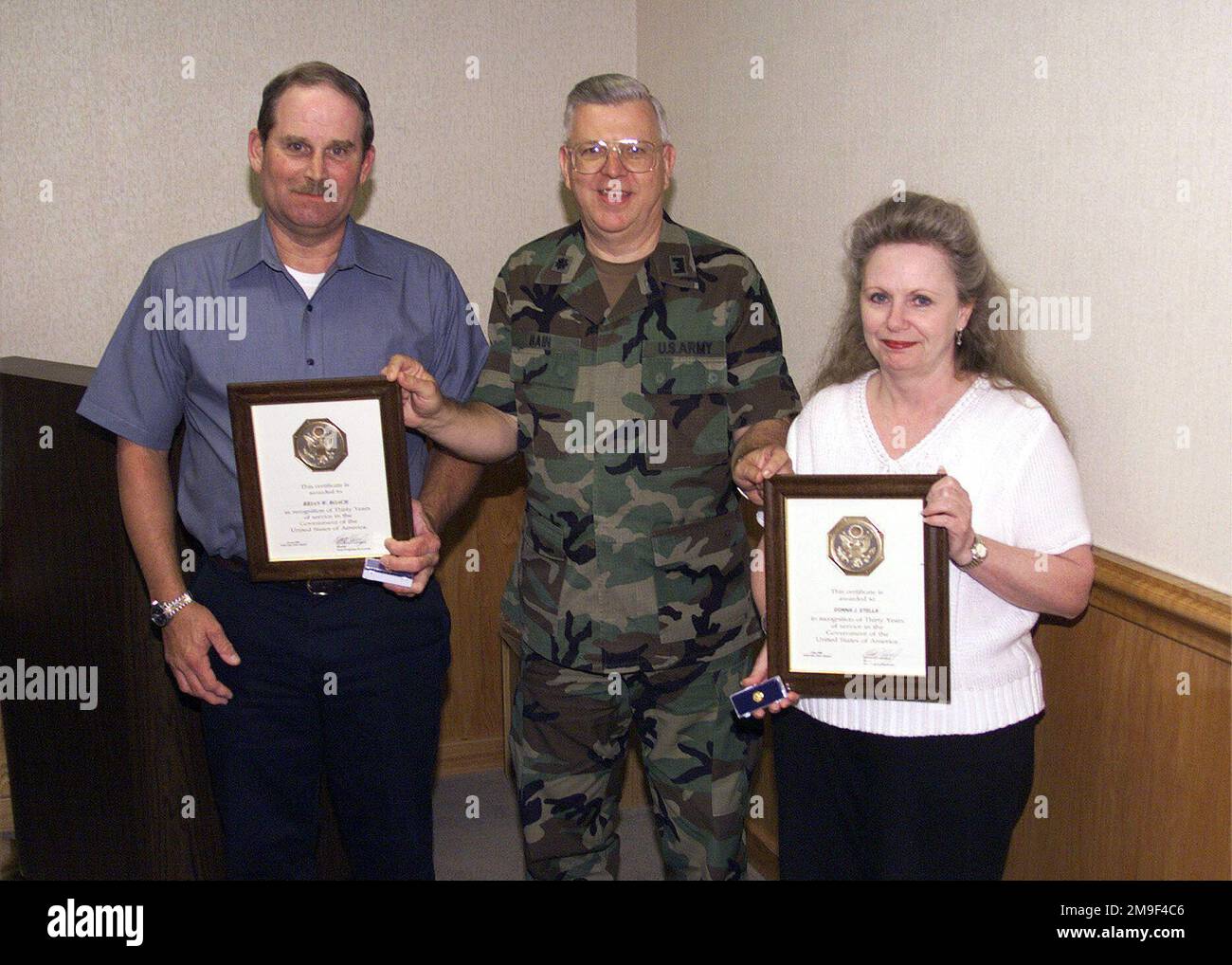 Lieutenant Colonel Dolas Bain presents Brian Roach, left and Donna Stella an award for 30 years of government service. Base: Fort Dix State: New Jersey (NJ) Country: United States Of America (USA) Stock Photo