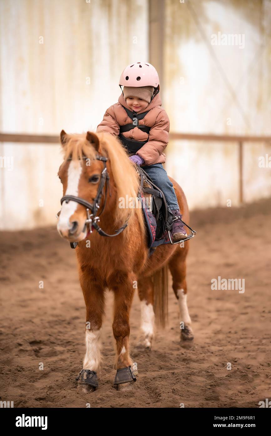 Little Child Riding Lesson. Threeyearold girl rides a pony and does