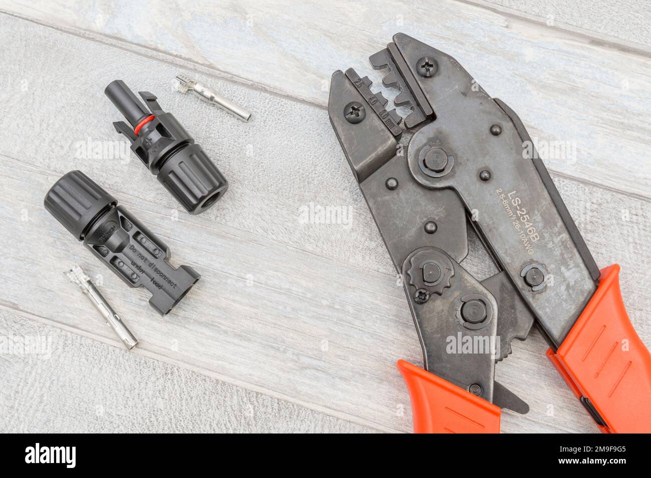 Chinese made unbranded MC4 Solar connector hand crimping tool alongside MC4 male and female solar cable connectors. Stock Photo