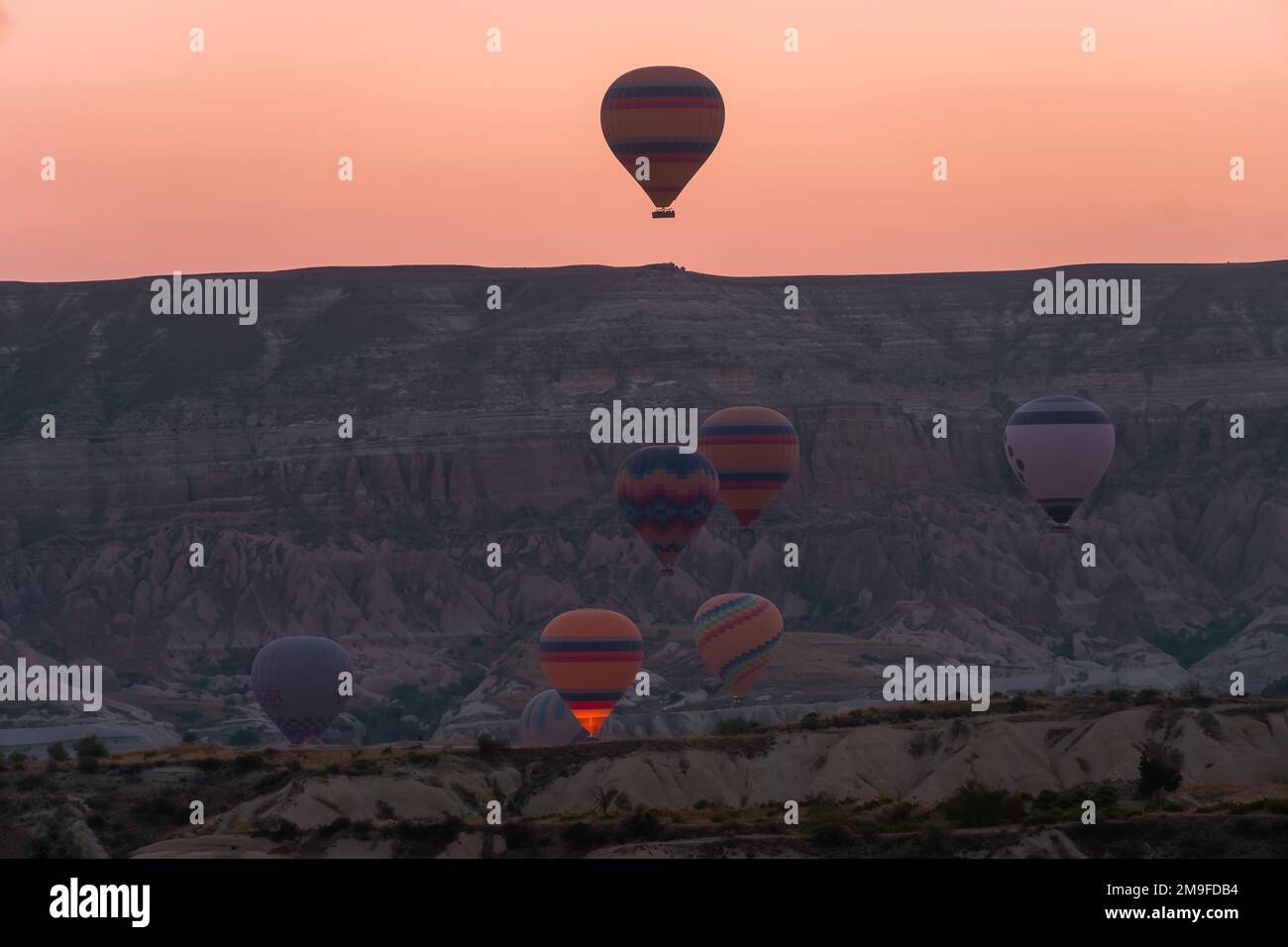 Balloons flying against the background of a beautiful sunrise in Cappadocia. A popular tourist destination for summer holidays Stock Photo