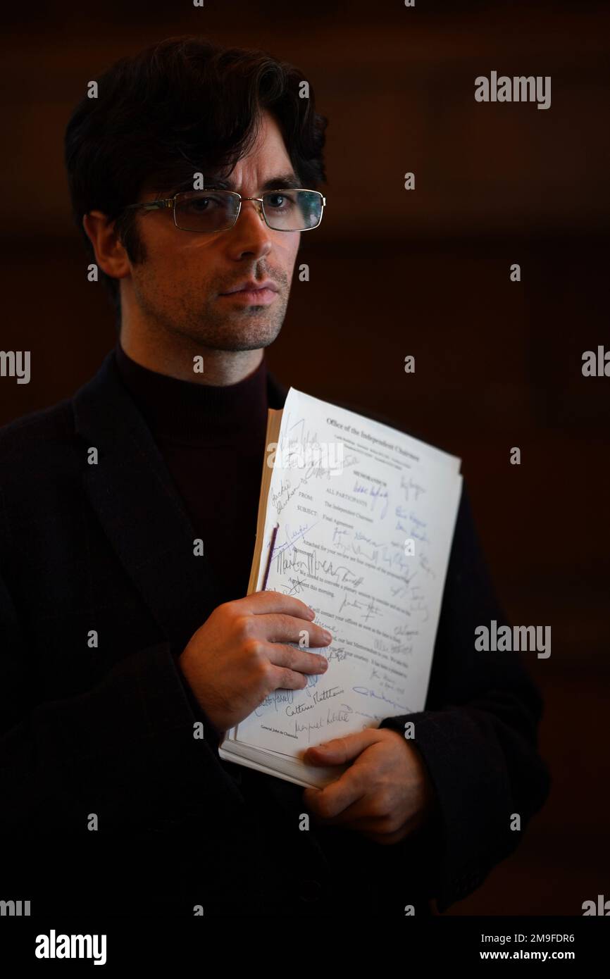 Actor Conor O'Kane holding a signed copy of the Good Friday Agreement