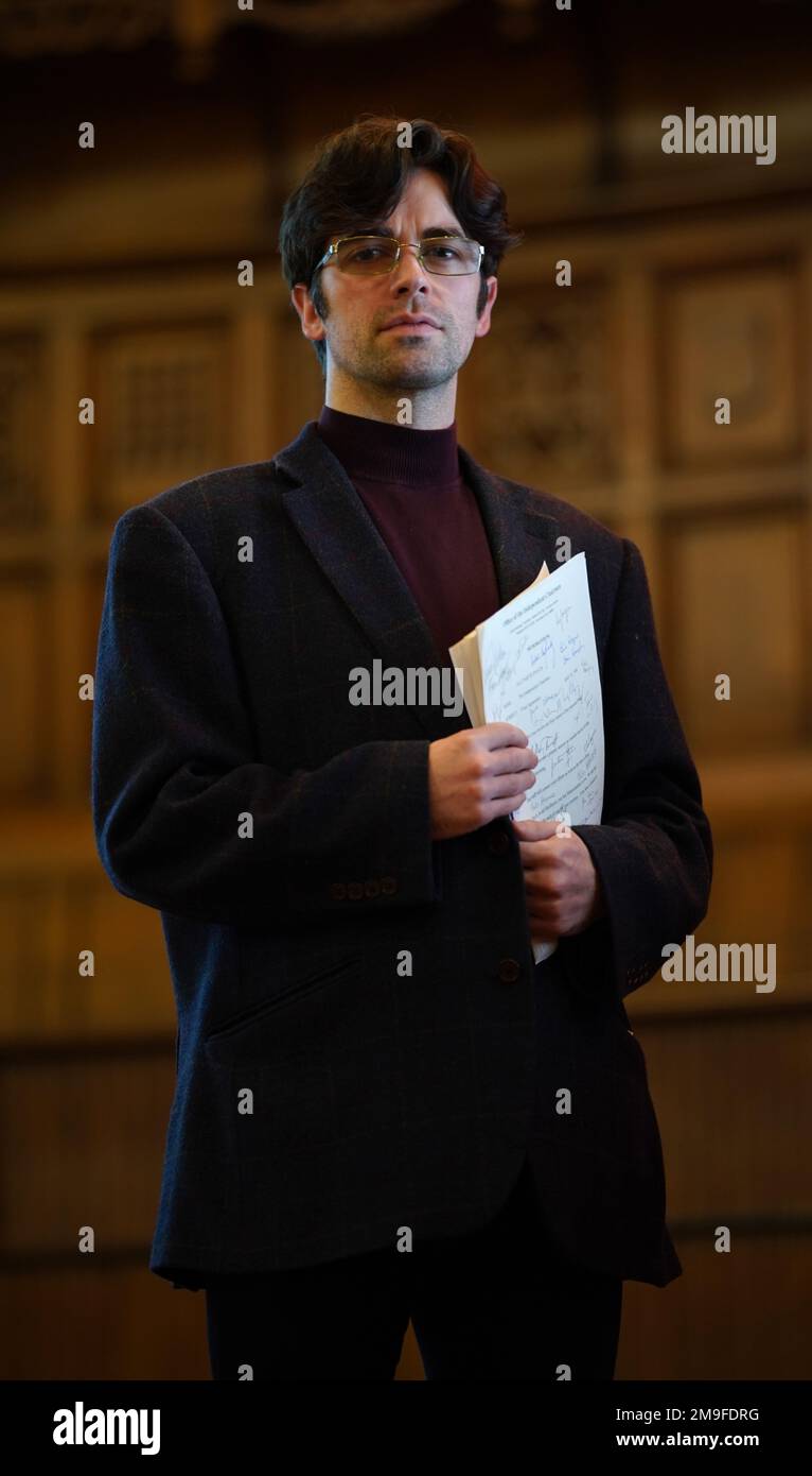Actor Conor O'Kane holding a signed copy of the Good Friday Agreement