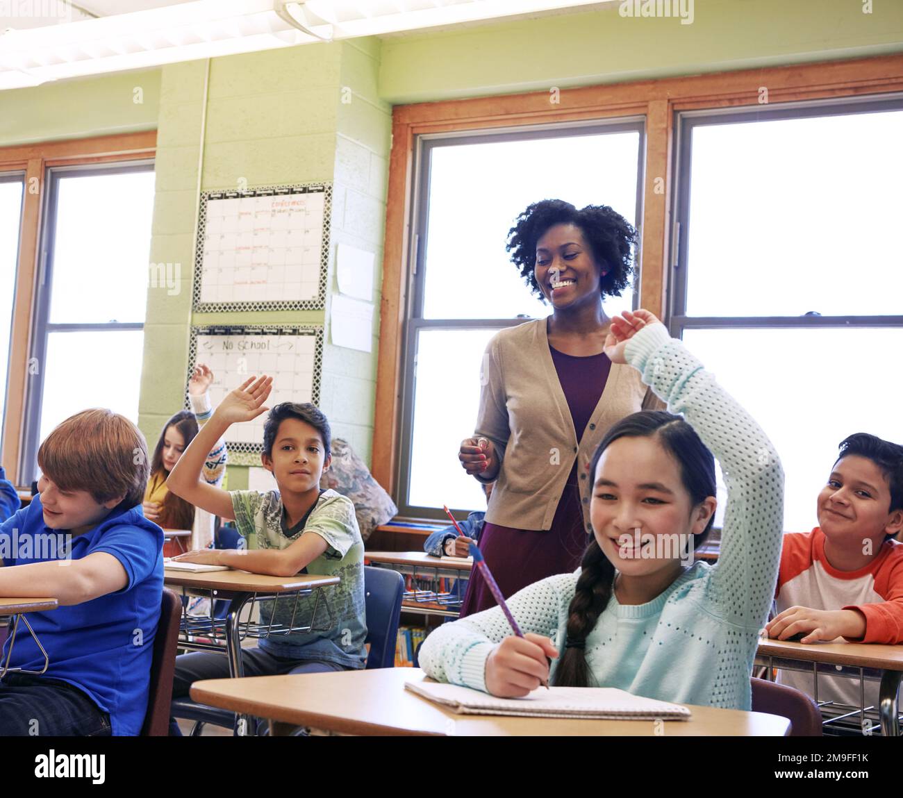 Education, teacher and kids raise their hands to ask or answer an academic question for learning. Diversity, school and primary school children Stock Photo