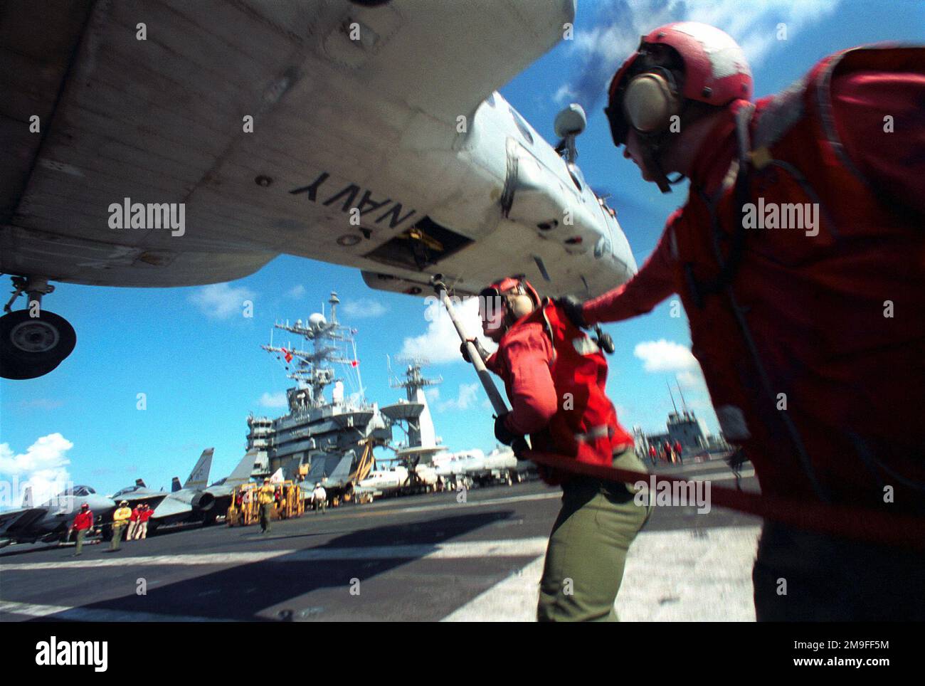 https://c8.alamy.com/comp/2M9FF5M/us-navy-aviation-ordnanceman-michael-tune-has-a-firm-grip-on-the-floatation-coat-of-us-navy-aviation-ordnanceman-airman-erik-white-as-he-attempts-to-rig-a-bundle-of-ammunition-slings-during-replenishment-at-sea-aboard-uss-harry-s-truman-cvn-75-slings-are-used-to-transfer-ammunitions-during-a-vertical-replenishment-at-sea-vertrep-truman-and-its-battle-group-are-participating-in-exercise-unified-spirit-a-nato-led-united-nations-training-exercise-simulating-peace-keeping-operations-off-the-atlantic-coast-subject-operationseries-unified-spirit-base-uss-harry-s-truman-cvn-75-2M9FF5M.jpg