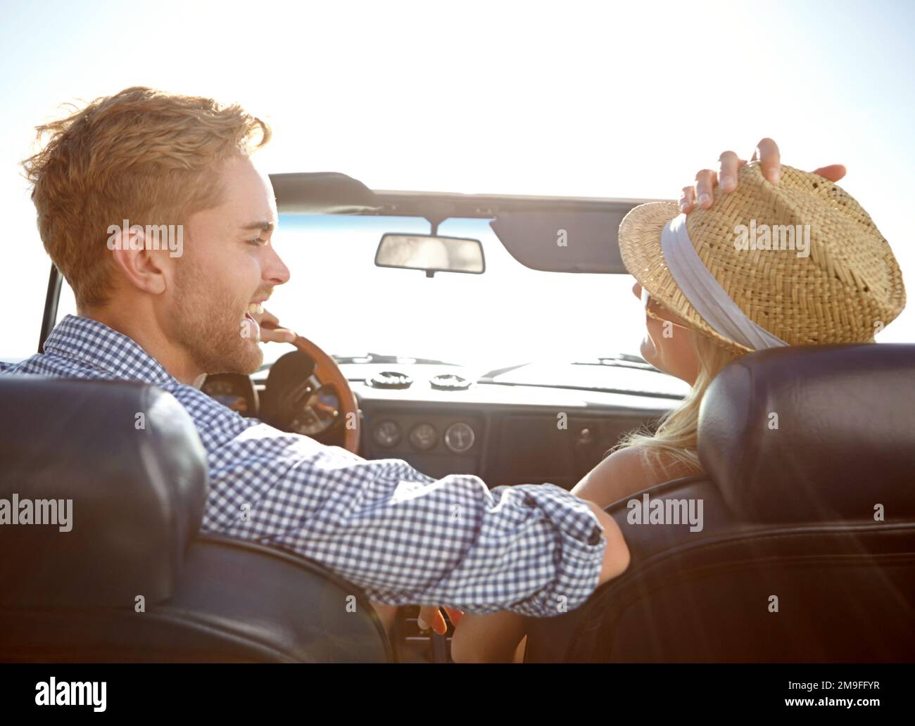 Car road trip, travel and back of couple on bonding holiday adventure, transportation journey or fun summer vacation. Love flare, convertible Stock Photo