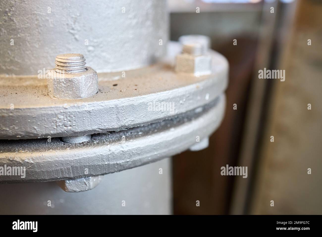 Bolted screw flenged connection, sealing connection on manhole of industrial machine compressor or pump on chemical plant selective focus with out of Stock Photo