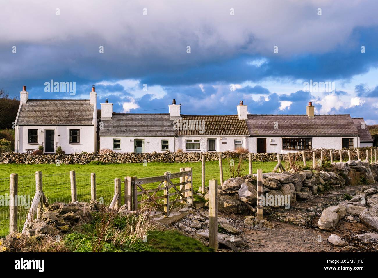 Row of quaint white Welsh cottages beside Anglesey Coastal Path on