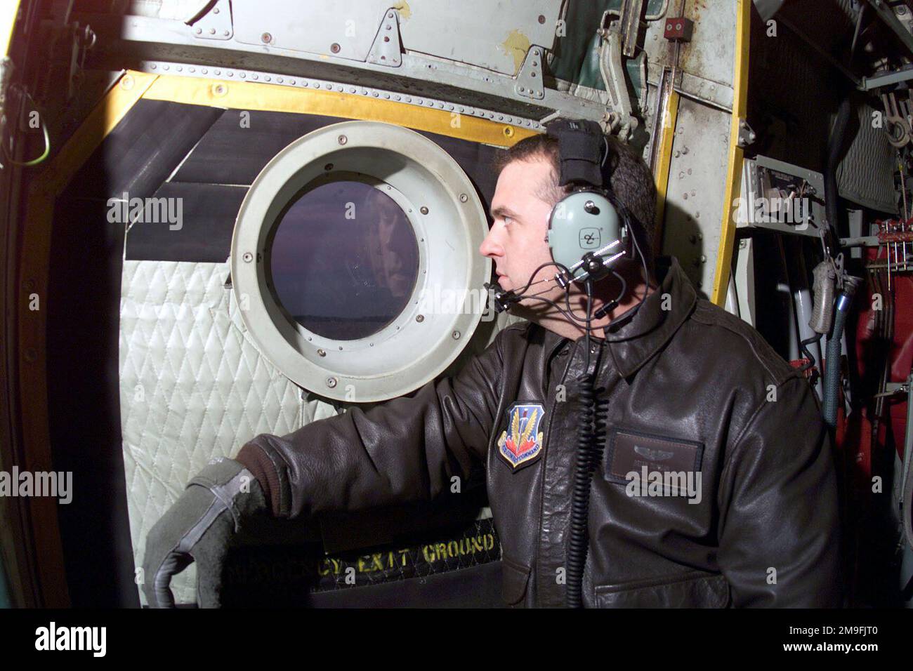 Technical Sergeant Brian Duncan looks out the paratroop door window of