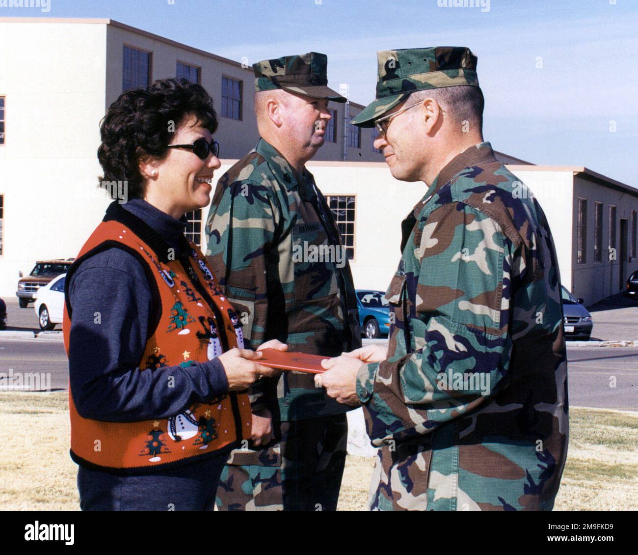 US Marine Colonel Mark A. Costa (Right), Base Commander, Marine Corps Logistics Base (MCLB), Barstow, California, presents a Certificate of Appreciation to Sandra Hathaway, wife of Base Sergeant Major John D. Hathaway (Center), at his retirement ceremony on December 22nd, 2000. Base: Usmc Logistics Base, Barstow State: California (CA) Country: United States Of America (USA) Stock Photo