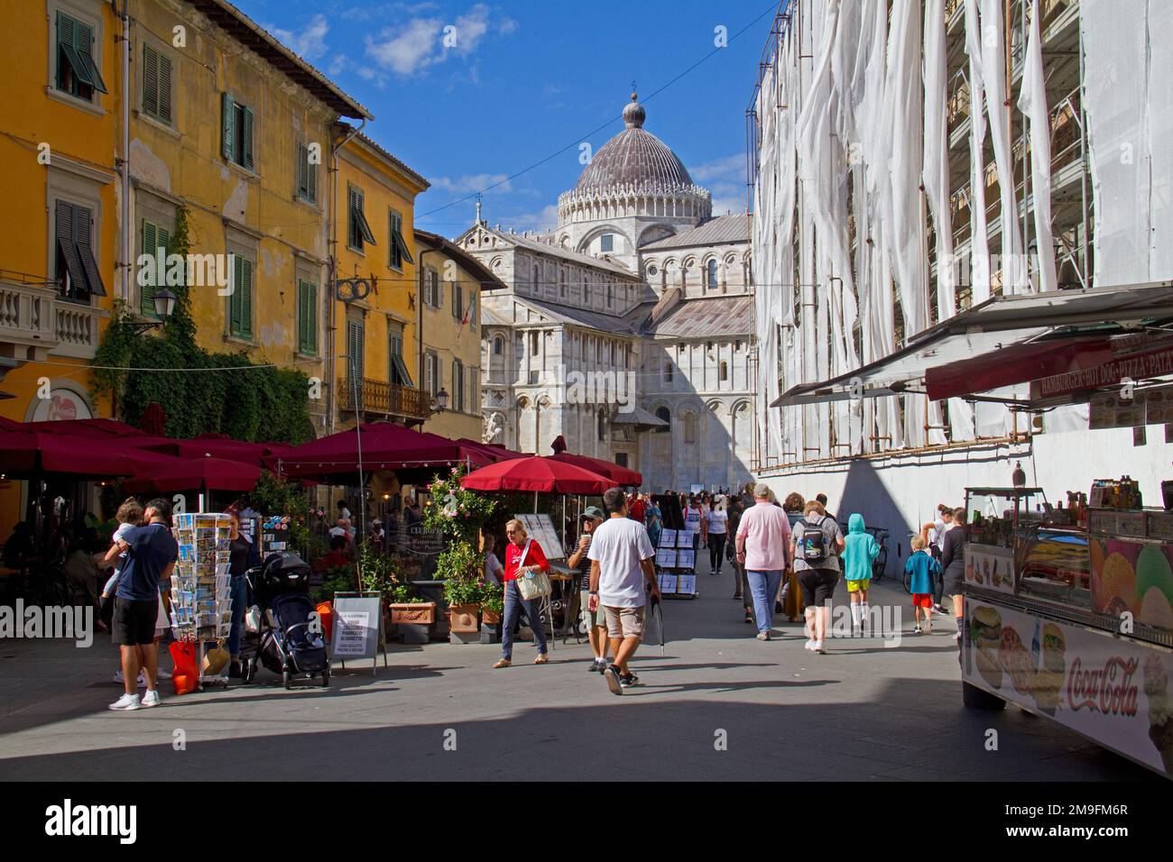 Tourists (unrecognizable) walking down a lively street, leading to the Dumo in Pisa Stock Photo