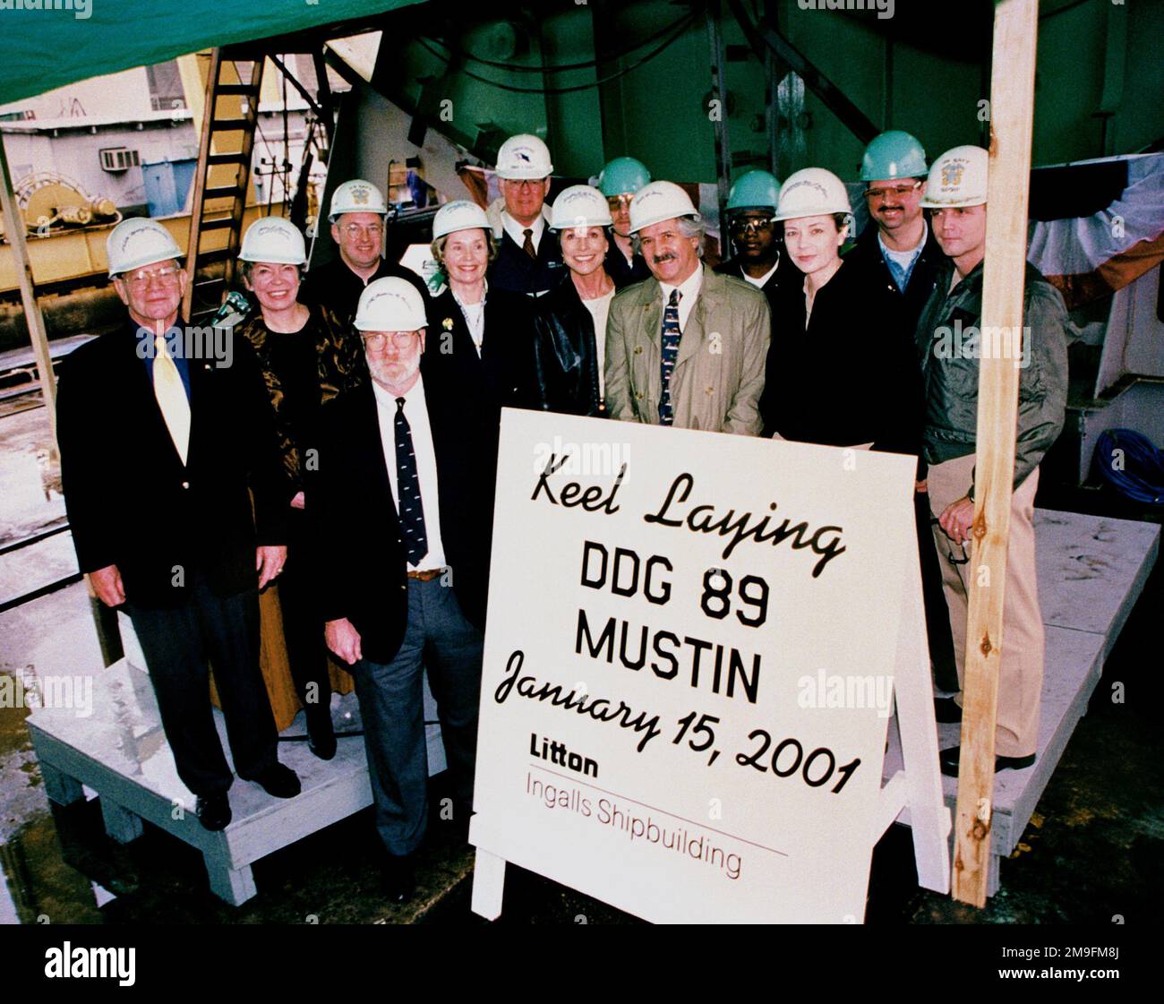 The participants in the official keel laying ceremony for the Arleigh Burke class Aegis guided missile destroyer USS MUSTIN (DDG 89) pose for a photograph. They are (left to right) Row 1 Vice Admiral (VADM) Henry M. Mustin, USN (Ret) and Lieutenant Commander (LCDR) Thomas M. Mustin, USN (Ret) grandson of the ships namesake; Row 2 Jean Mustin, Ships Sponsor; Doug St. Denis, Ships Sponsor; Dale St. Denis, husband of Doug St. Denis; Commander (CDR) Ann Phillips, USN, PCO; Captain Philip Johnson, USN, Supervisor of Shipbuilding, Pascagoula; Row 3 CDR Steve Metz, Aegis Area Commander/Destroyer Proj Stock Photo