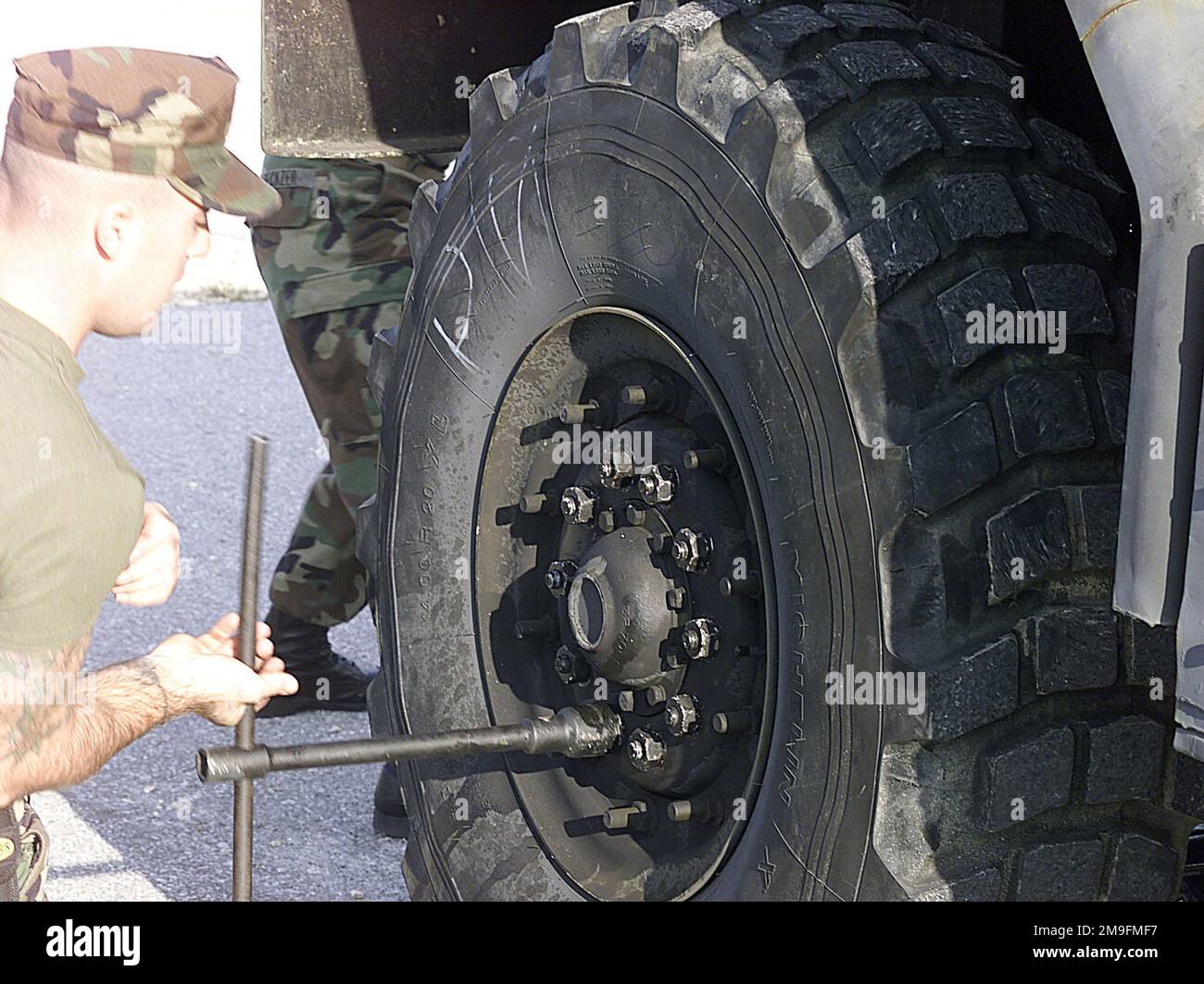 Corporal (CPL) John C. Holtzapple from MAG-36, removes lugnuts from a tire on a M913 5-ton truck as his partner CPL Daric J. Zeckzer is in front of the truck jacking it up during the tire changing portion of the 1ST Marine Air Wing (MAW) Truck Rodeo. The purpose of the Truck Rodeo is to find the Marines most efficient at thier respective job so they can represent the 1ST MAW at the III Marine Expeditionary Force Truck Rodeo. Base: Marine Corps Base, Camp Foster State: Okinawa Country: Japan (JPN) Stock Photo