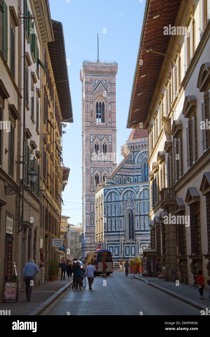 Shaded street in Florence, leading to the sunlit Giottos Bell Tower Stock Photo