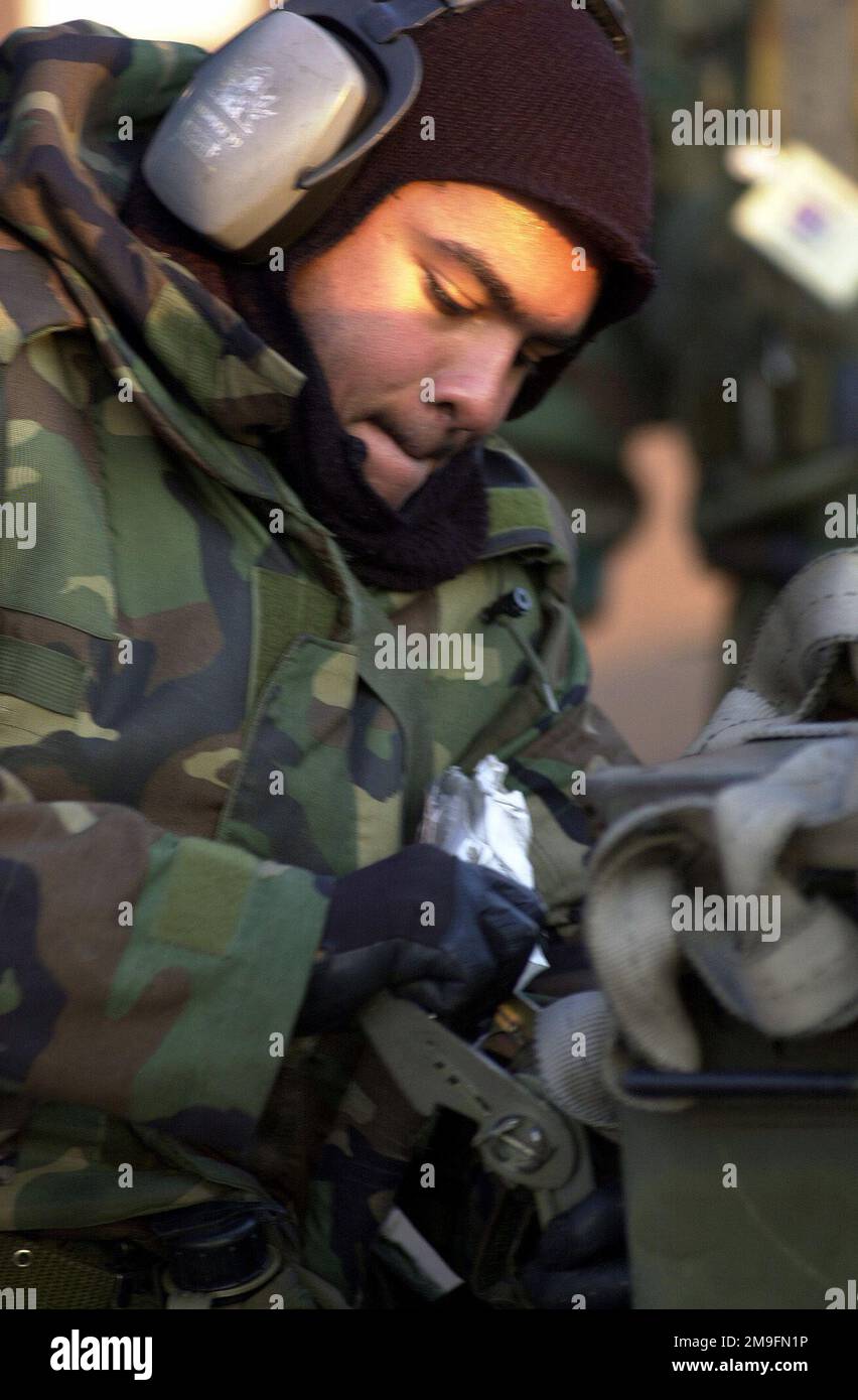 US Air Force AIRMAN First Class Jonathan Nobre struggles to loosen a tie-down from a GBU-10 at Osan Air Base, Republic of Korea, during Osan's Initial Response Readiness Exercise/Combat Employment Readiness Exercise. Base: Osan Air Base Country: Republic Of Korea (KOR) Stock Photo