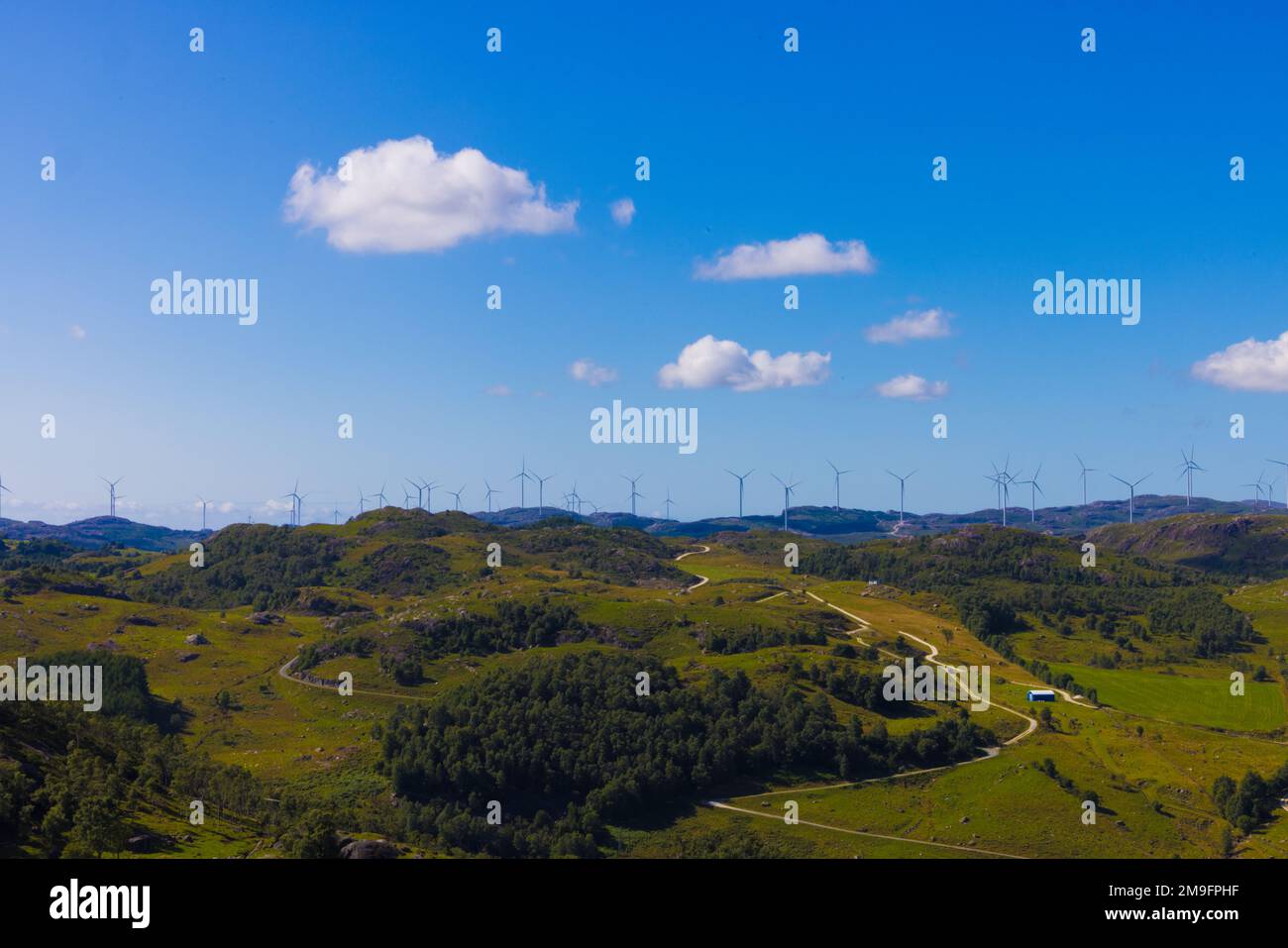 An aerial view of green rural landscape with wind turbines in the ...