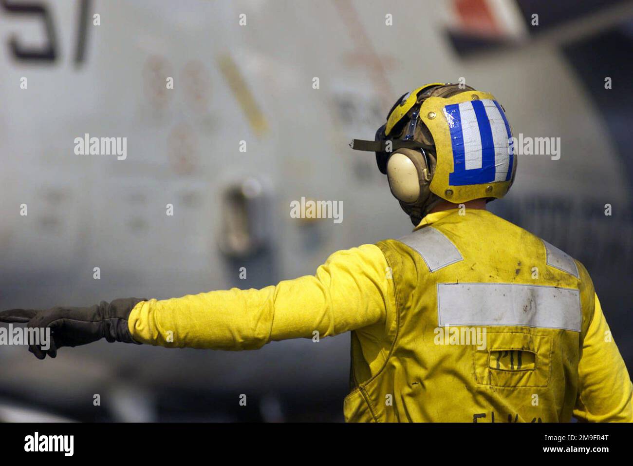 Aviation Boatswain's Mate (Handler) First Class Jason Kjos directs an EA6B Prowler from