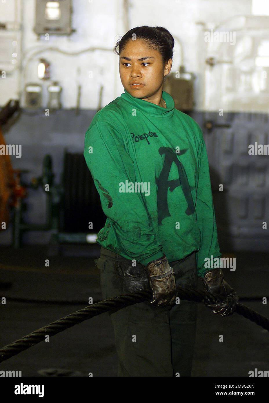 US Navy AIRMAN Cassie Poepoe flanks out an arresting gear cable in the hangar bay of USS HARRY S. TRUMAN (CVN 75). Arresting cables are used on the flight deck to arrest or stop the aircraft as it lands on the flight deck. Truman is on station in the Persian Gulf in support of Operation SOUTHERN WATCH. Subject Operation/Series: SOUTHERN WATCH Base: USS Harry S. Truman (CVN 75) Stock Photo