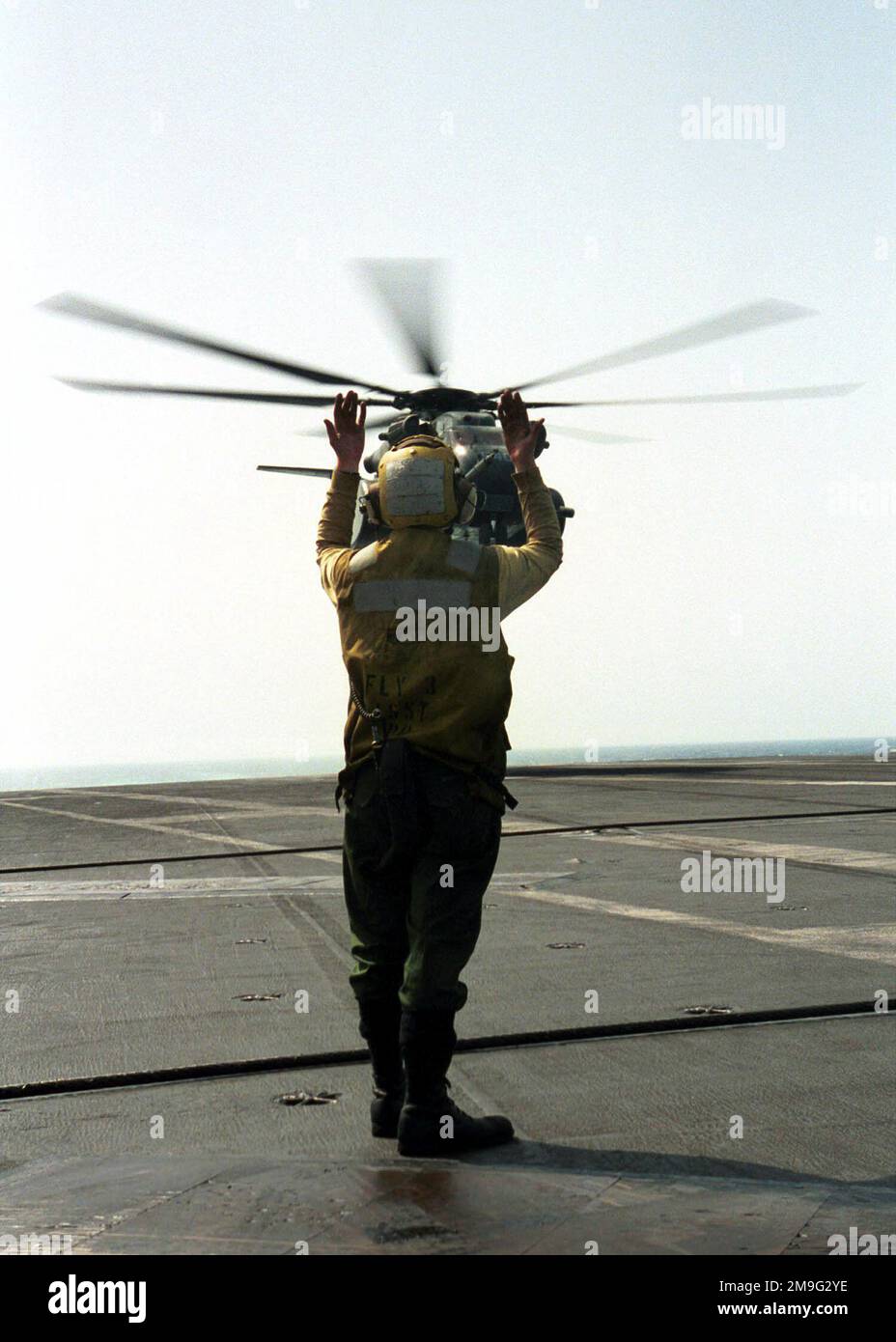 US Navy Aviation Boatswain's Mate First Class Jason Kjos directs a CH