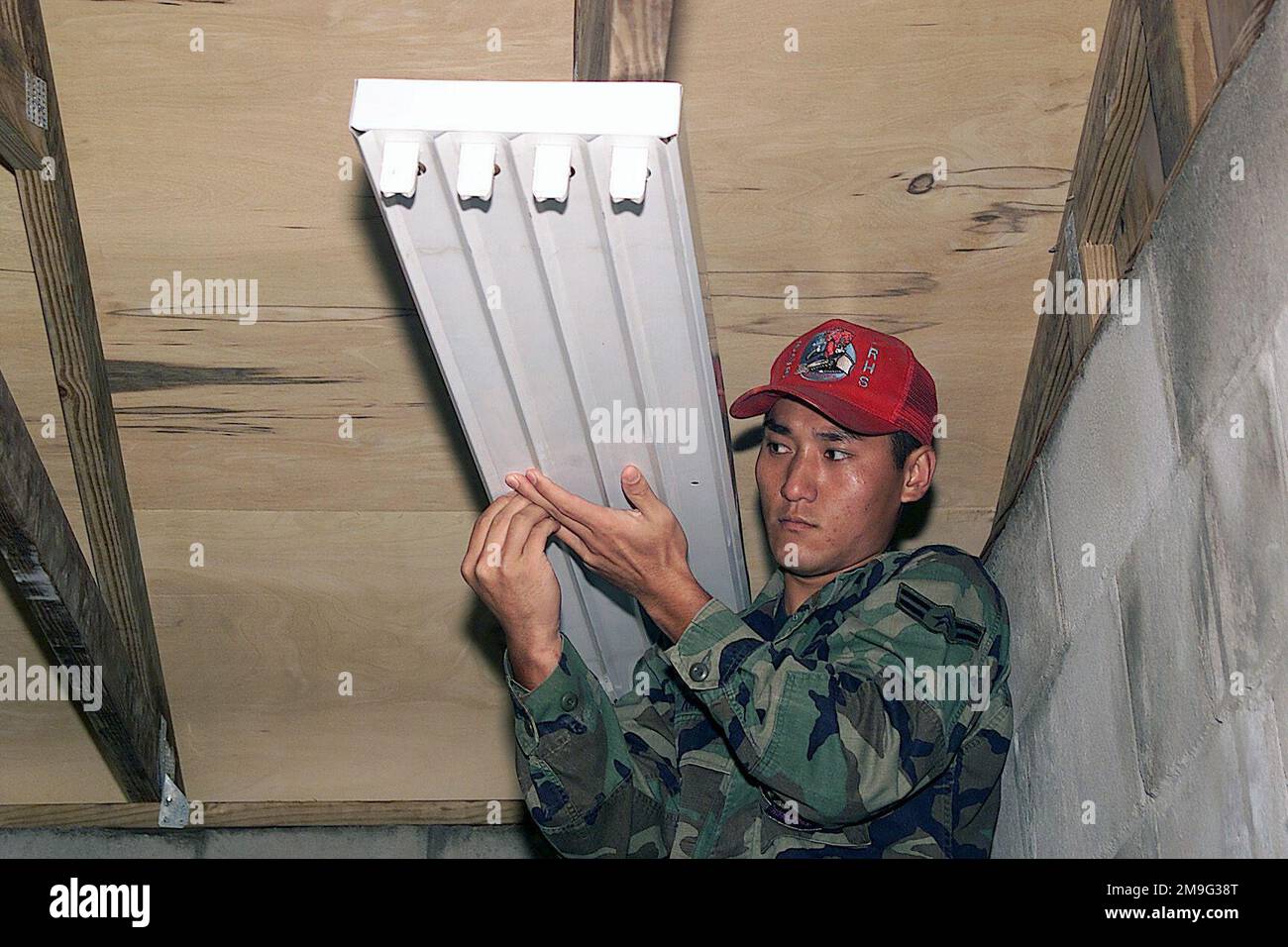 US Air Force AIRMAN First Class Kwang Kim, Electrician, 823rd Red Horse Squadron, secures a light fixture for the new school at Las Palmas Paraguay, during Exercise NEW HORIZONS. Combined Task Force Guarani Springs conducts engineering and medical operations in Paraguay, enabling joint training. The task force will renovate, construct and improve the infrastructure of four schools, four water wells, two medical clinics, and conduct mutable Medical Readiness Training Exercises (MEDRETES), and Veterinarian Readiness Training Exercises (VETRETES) as agreed to by the government of Paraguay. Subjec Stock Photo