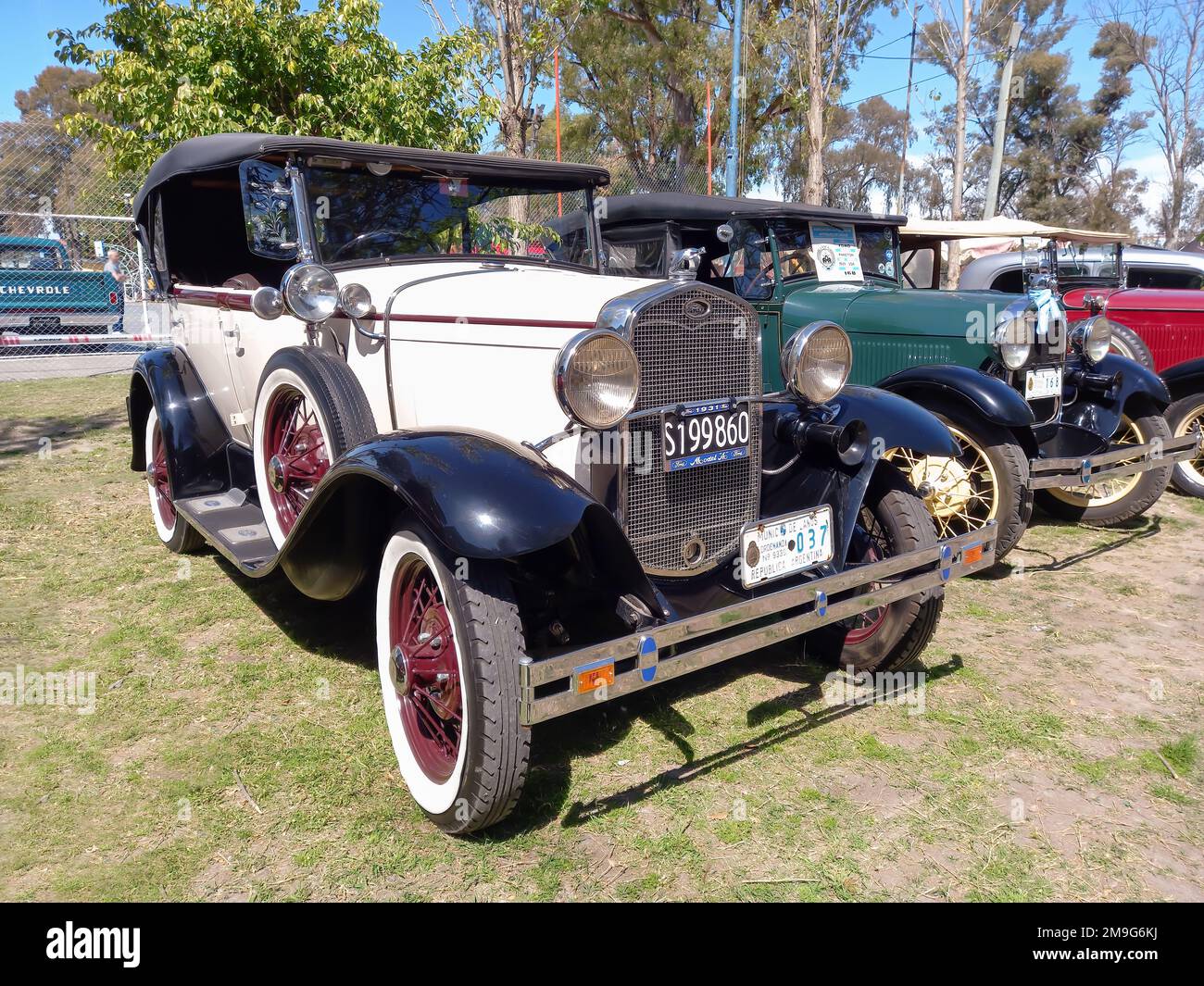 Vintage white 1931 Ford Model A four door Phaeton convertible by General Motors in a park. Nature, grass, trees. AAA 2022 classic car show. Stock Photo