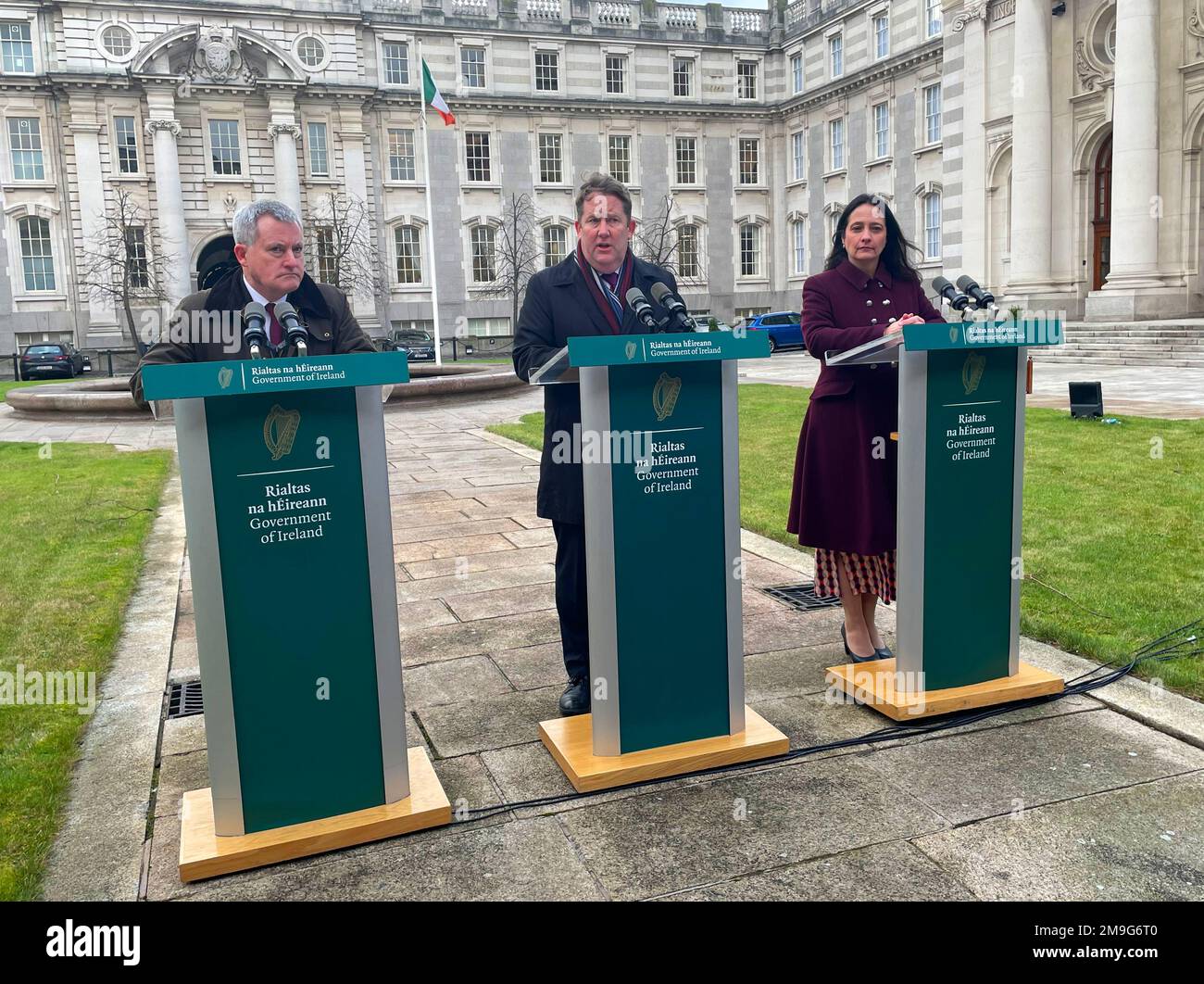 (left to right) Minister of State Kieran O'Donnell, Minister for Housing Darragh O'Brien and Minister for Tourism and the Arts Catherine Martin speak to to the media outside Government Buildings in Dublin about a new scheme to cover the costs of defective apartments built during the Celtic Tiger. The Government has announced a multi-million euro scheme to repair Celtic Tiger-era apartments, after it was revealed that thousands across the country were not built to standard. Cabinet has agreed to draft legislation to support the remediation of apartments and duplexes with fire safety, structural Stock Photo