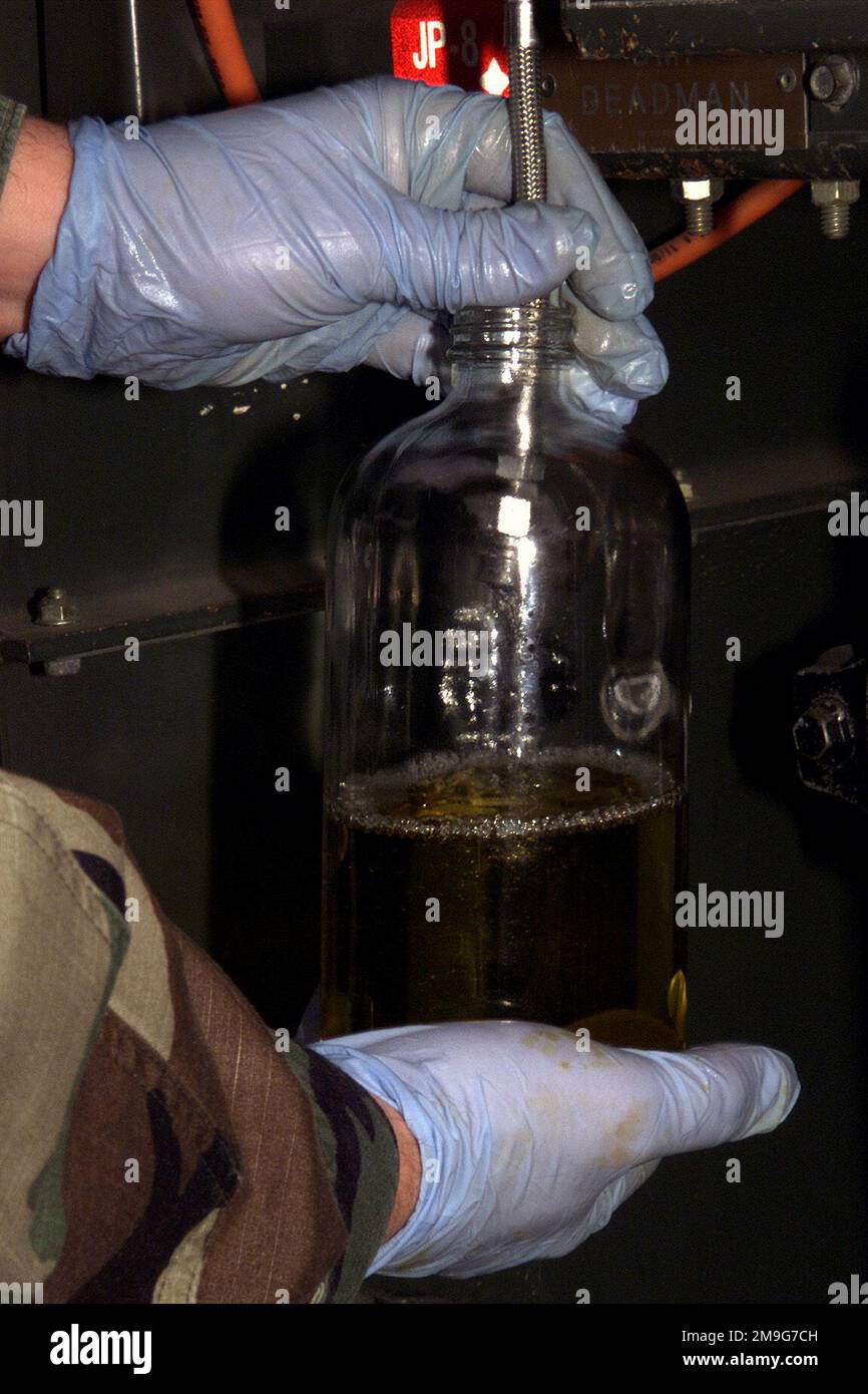 AIRMAN 1ST Class Mike Kresser, 92d Supply, takes a fuel sample from a