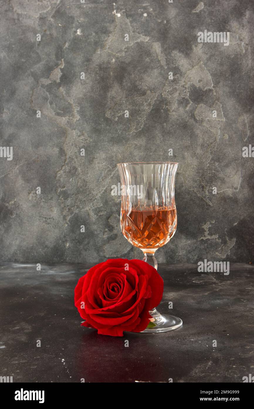 Close up two glasses of liquor and a rose on a black background. Stock Photo