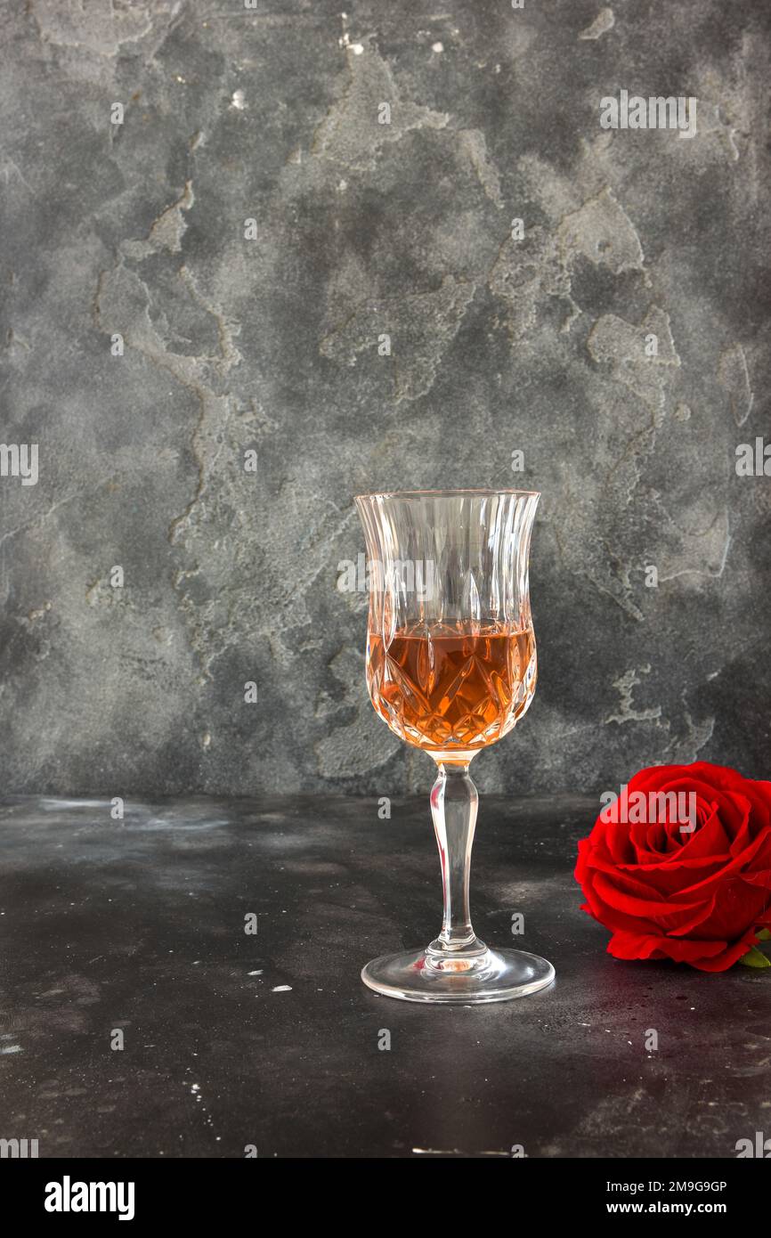 Close up two glasses of liquor and a rose on a black background. Stock Photo