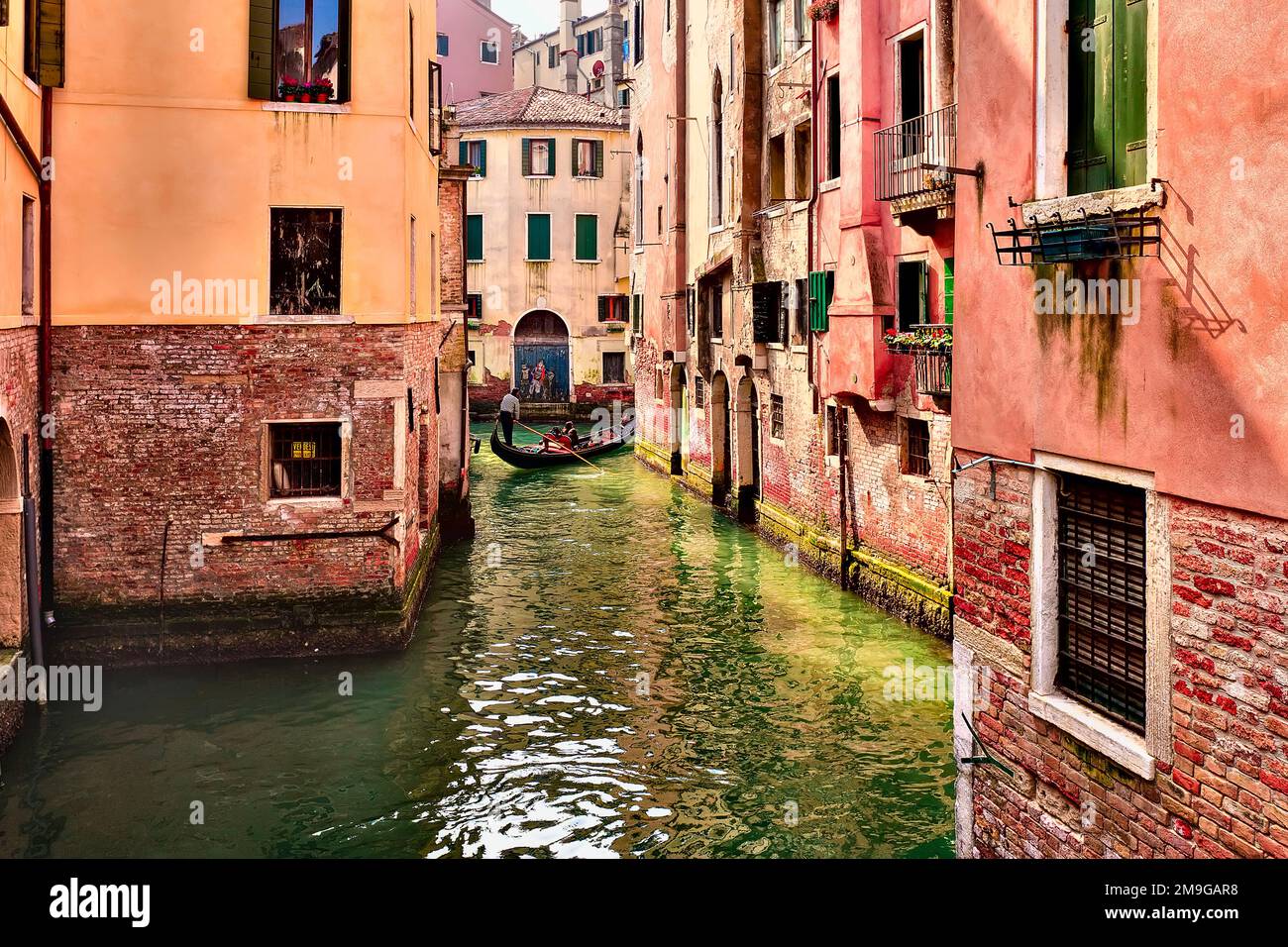 Distant view of gondola in canal in old town of Venice, Italy Stock Photo