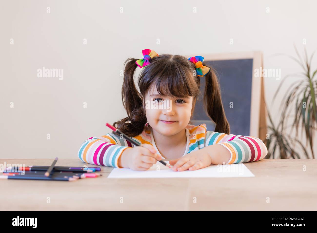 cute little girl draws with colored pencils Stock Photo - Alamy