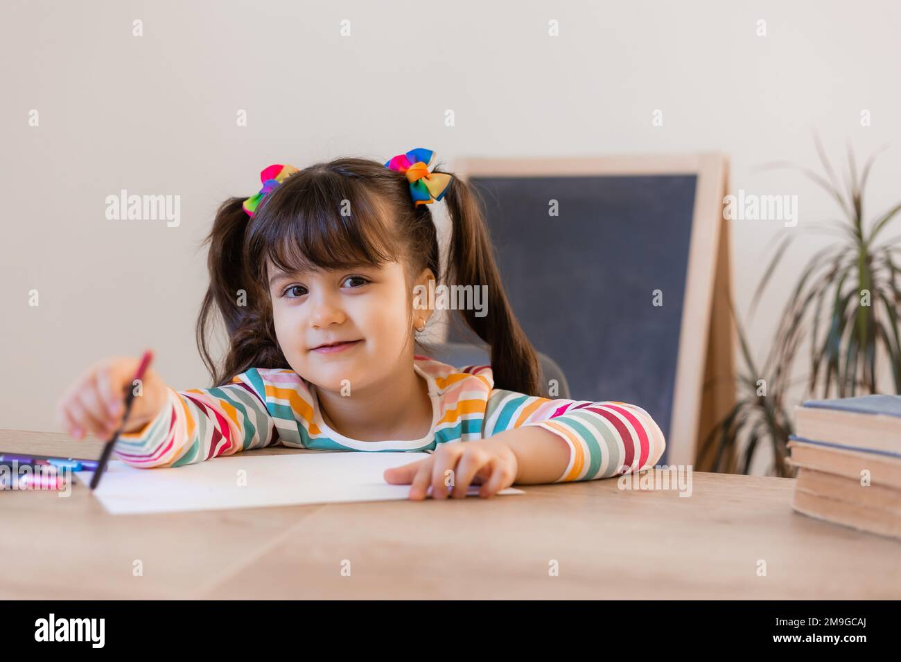 cute little girl draws with colored pencils Stock Photo - Alamy