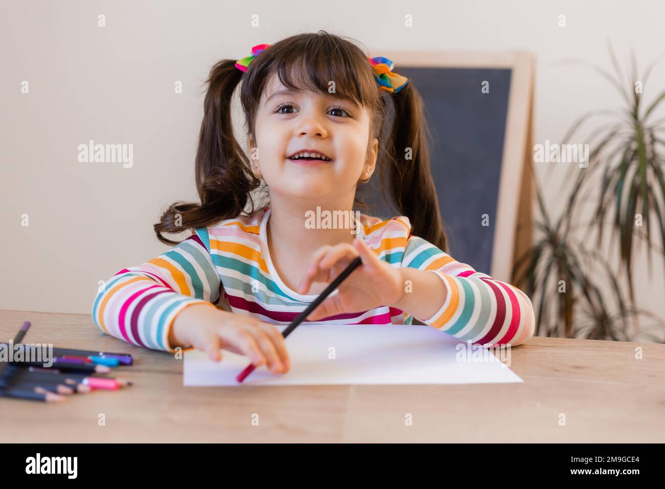 cute little girl draws with colored pencils Stock Photo - Alamy