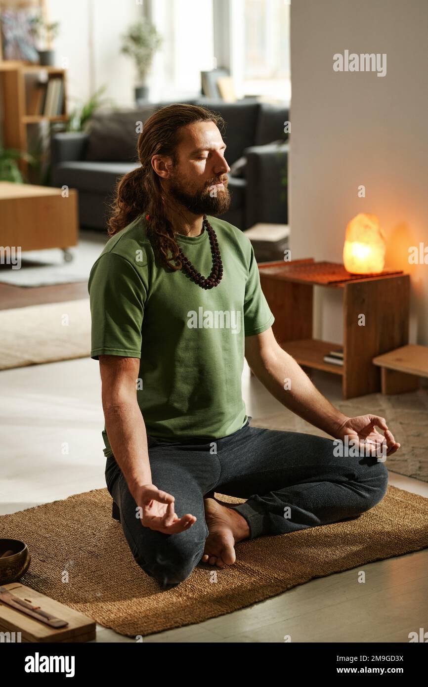 Young man sitting in lotus position and concentrating with his eyes ...