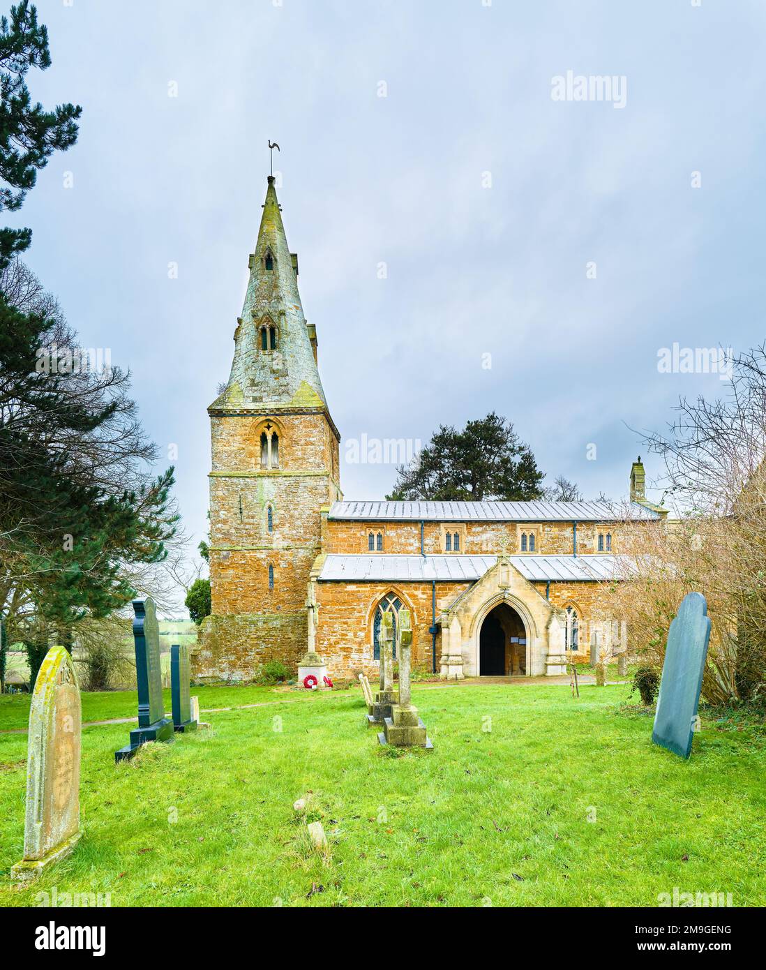 The churchyard at the medieval fourteenth century christian church in the village of Wilbarston, England. Stock Photo