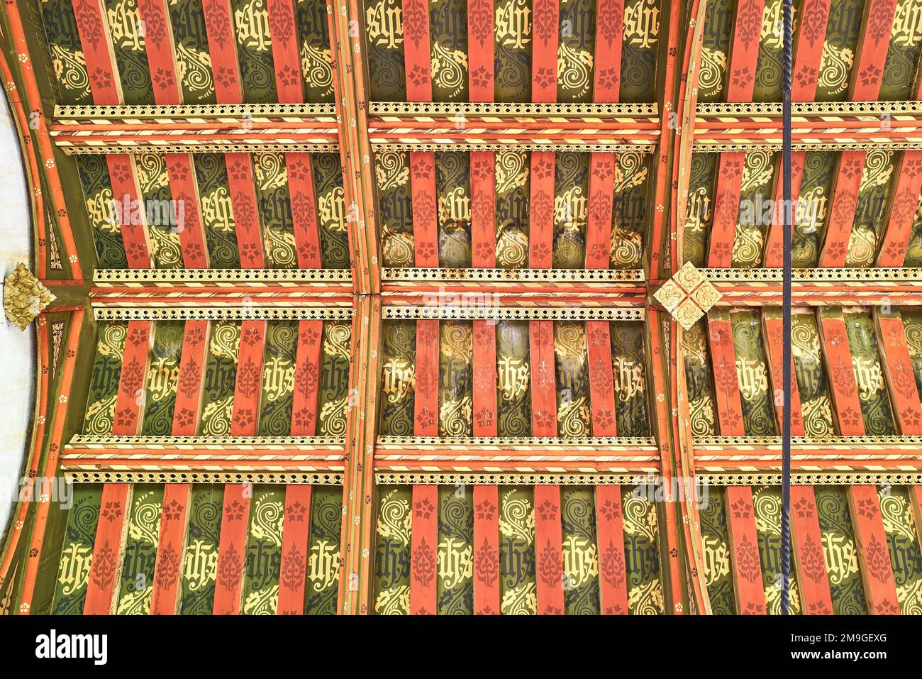 The monogram JHS or IHS on the painted wooden ceiling at the medieval fourteenth century christian church in the village of Wilbarston, England. Stock Photo