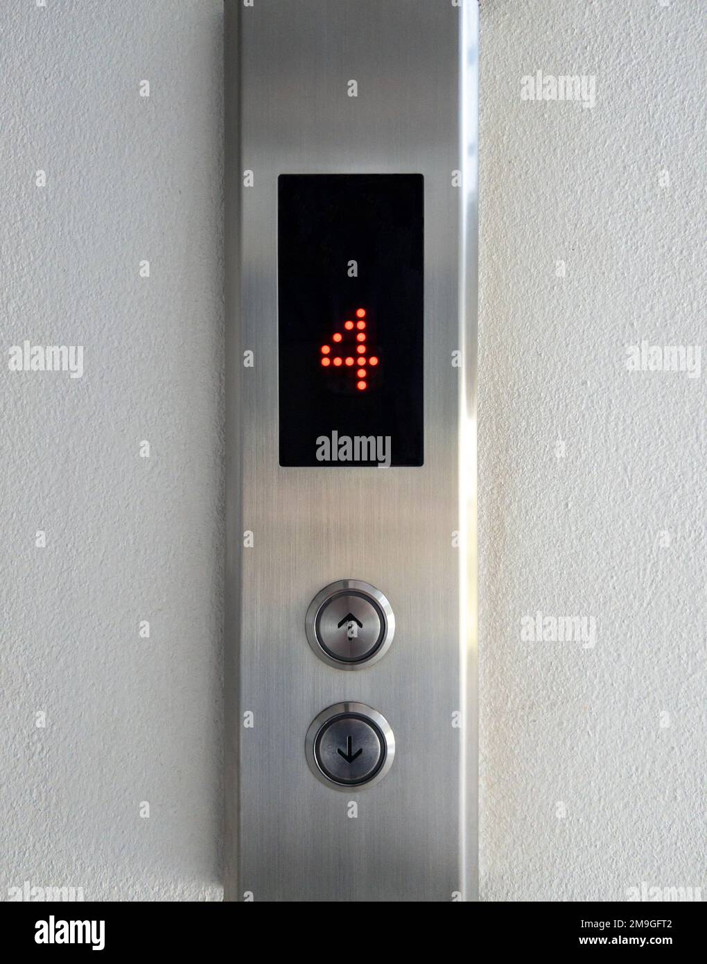 The arrow symbol with the braille on the push button of the metal panel in the passenger elevator, office building in the urban area, front view with Stock Photo
