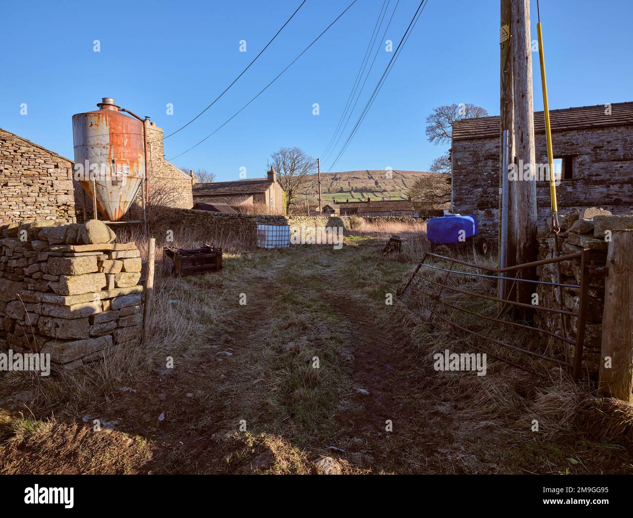 Farm entrance with farm buildings, hopper and storage with bright blue