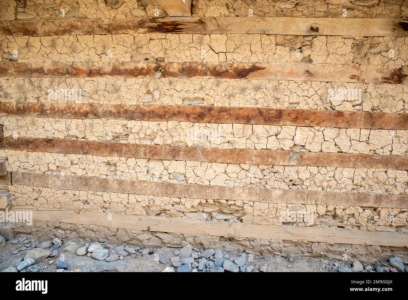 Wall of a traditional house where dry masonry and alternate layers of wood beams, Shaikhanandah village, Bumburet Valley, Pakistan Stock Photo