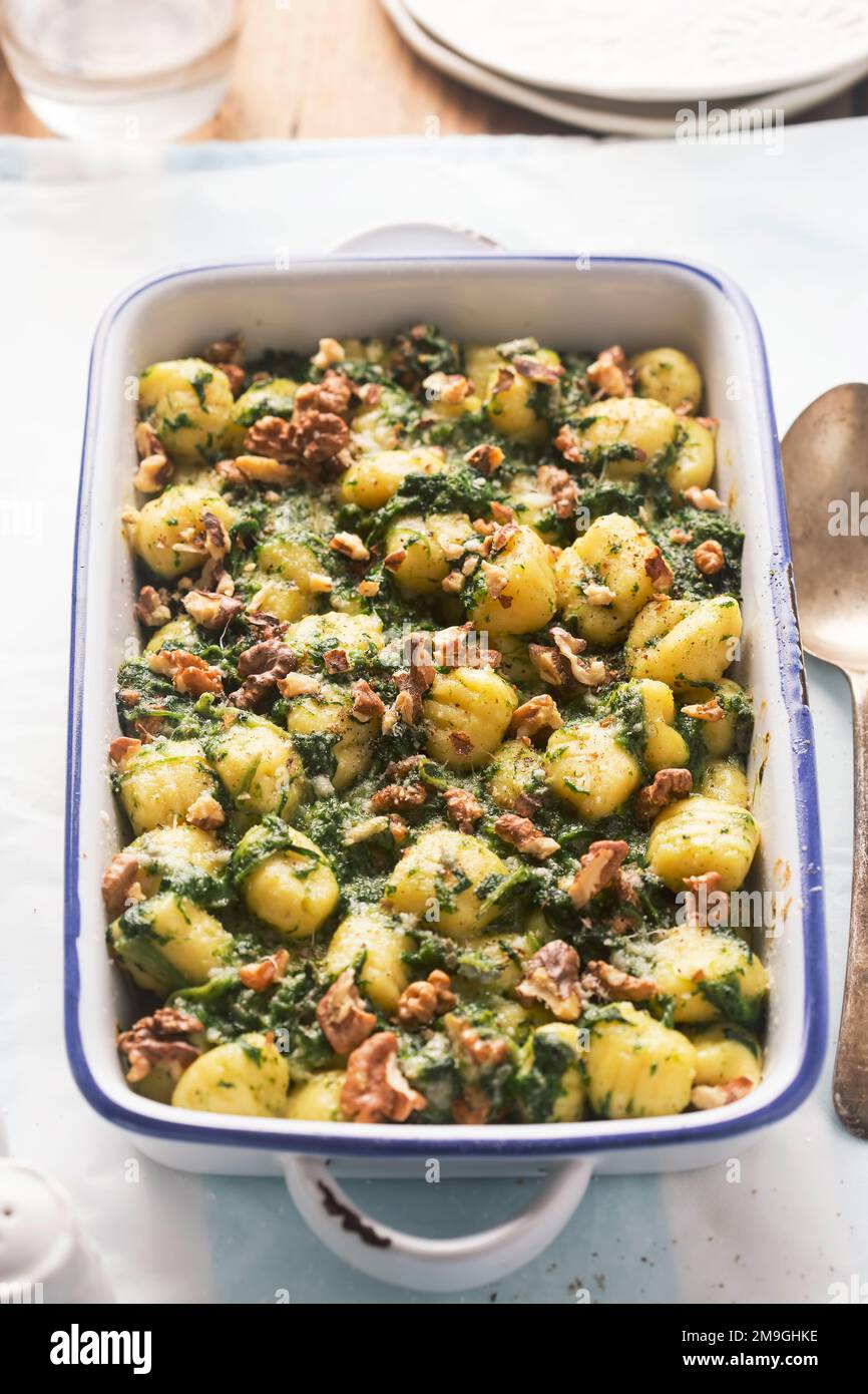 Italian gnocchi with spinach and walnuts bake Stock Photo
