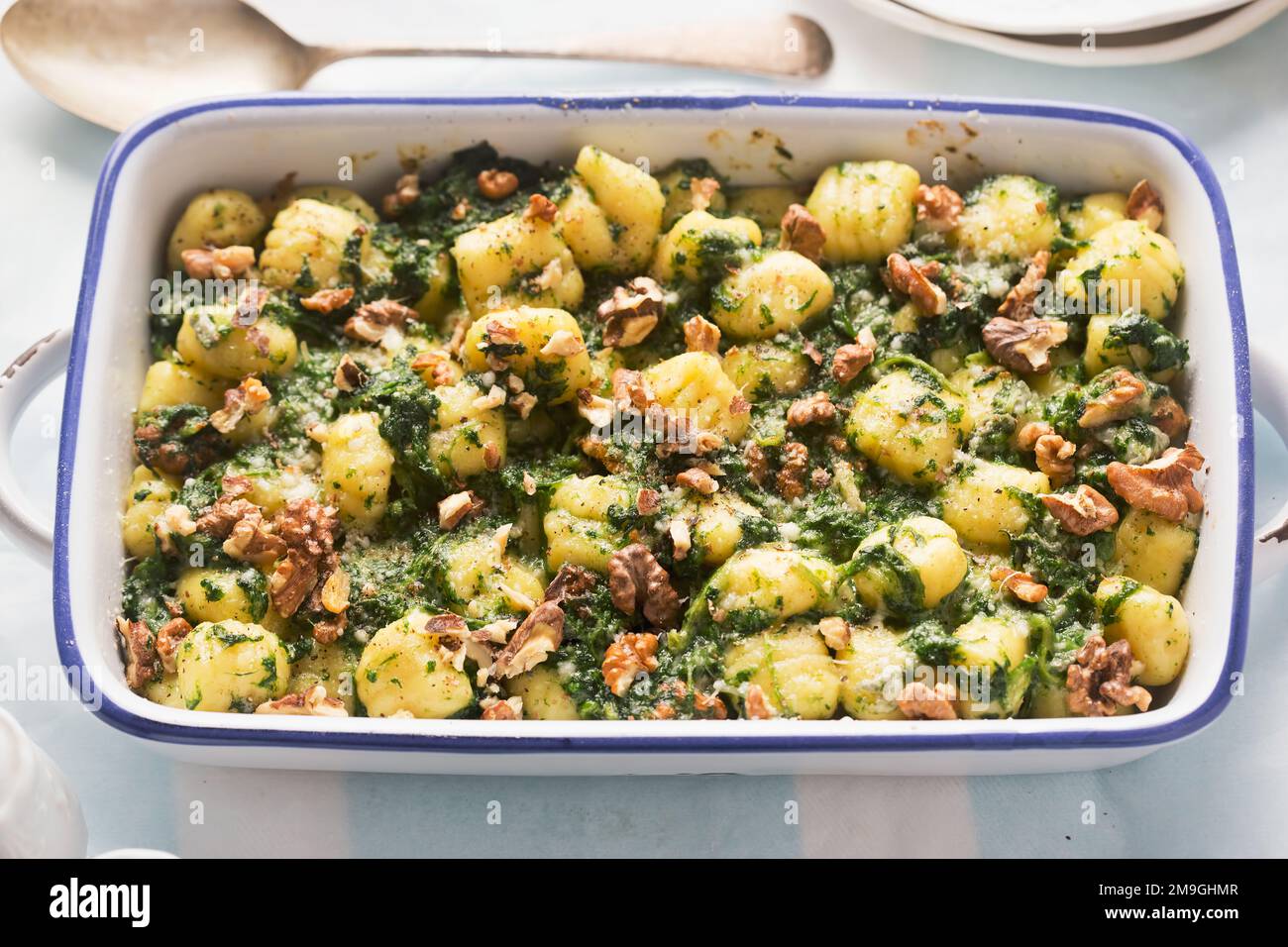 Italian gnocchi with spinach and walnuts bake Stock Photo
