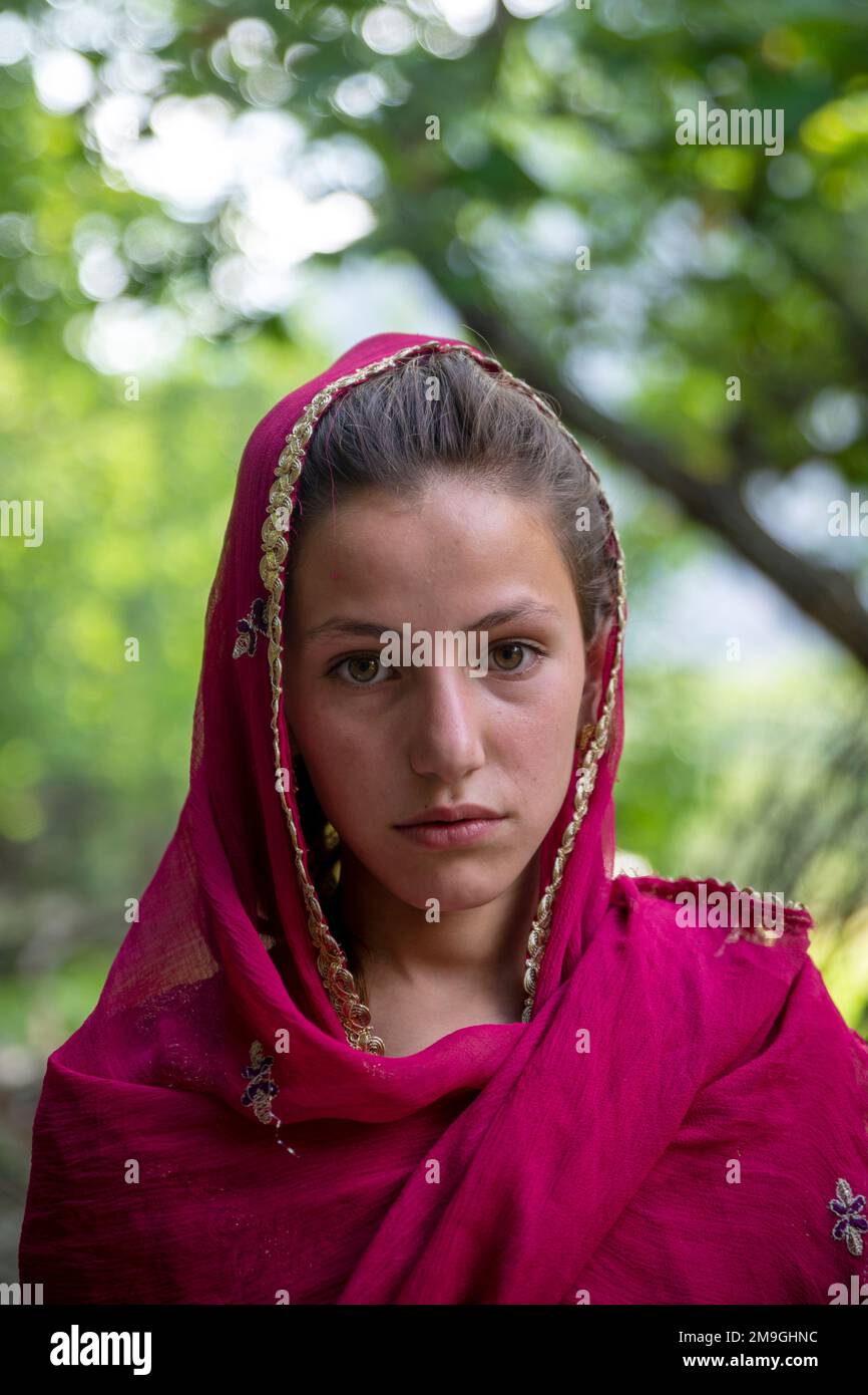 Portrait of a young Pashtun girl with red headscarf, Bumburet Valley, Pakistan Stock Photo