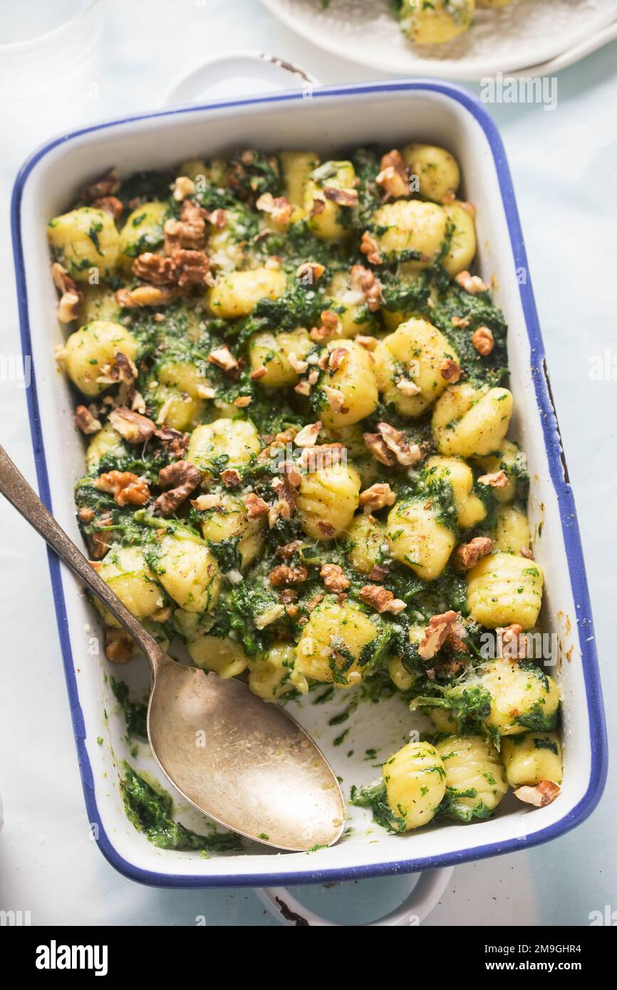 Italian gnocchi with spinach and walnuts bake Stock Photo