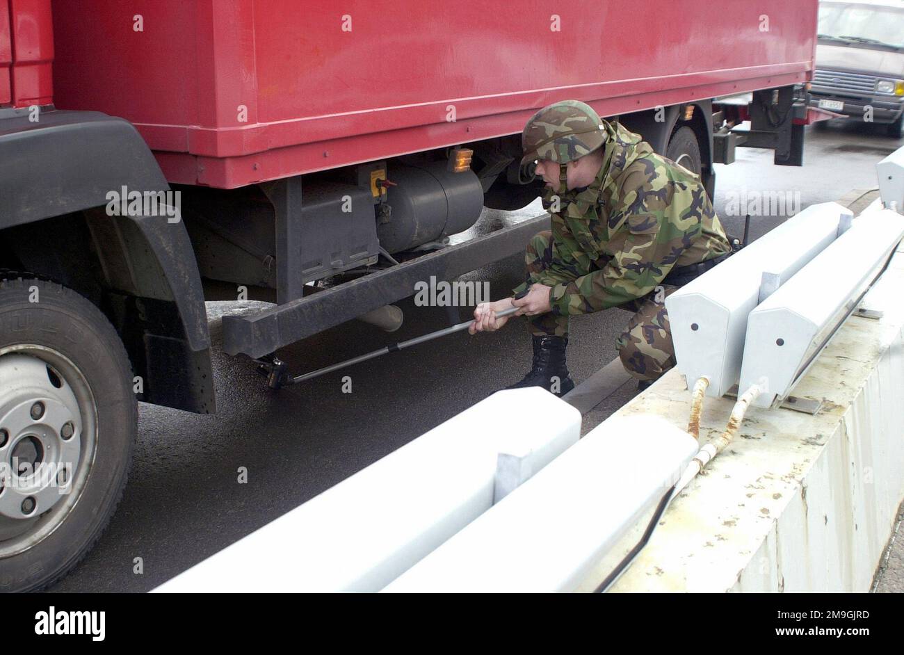 AIRMAN First Class Richard Warren, USAF, 568th Security Forces Squadron, Ramstein Air Base, Germany, uses a mirror to check the underside of a delivery truck before it can enter the West Gate. The 11 September 2001 terrorist attacks against the United States, when hijackers deliberately flew civilian airliners into the buildings, killing themselves, the passengers and thousands on the ground, placed bases on a higher state of force protection. Base: Ramstein Air Base State: Rheinland-Pfalz Country: Deutschland / Germany (DEU) Scene Major Command Shown: USAFE Stock Photo